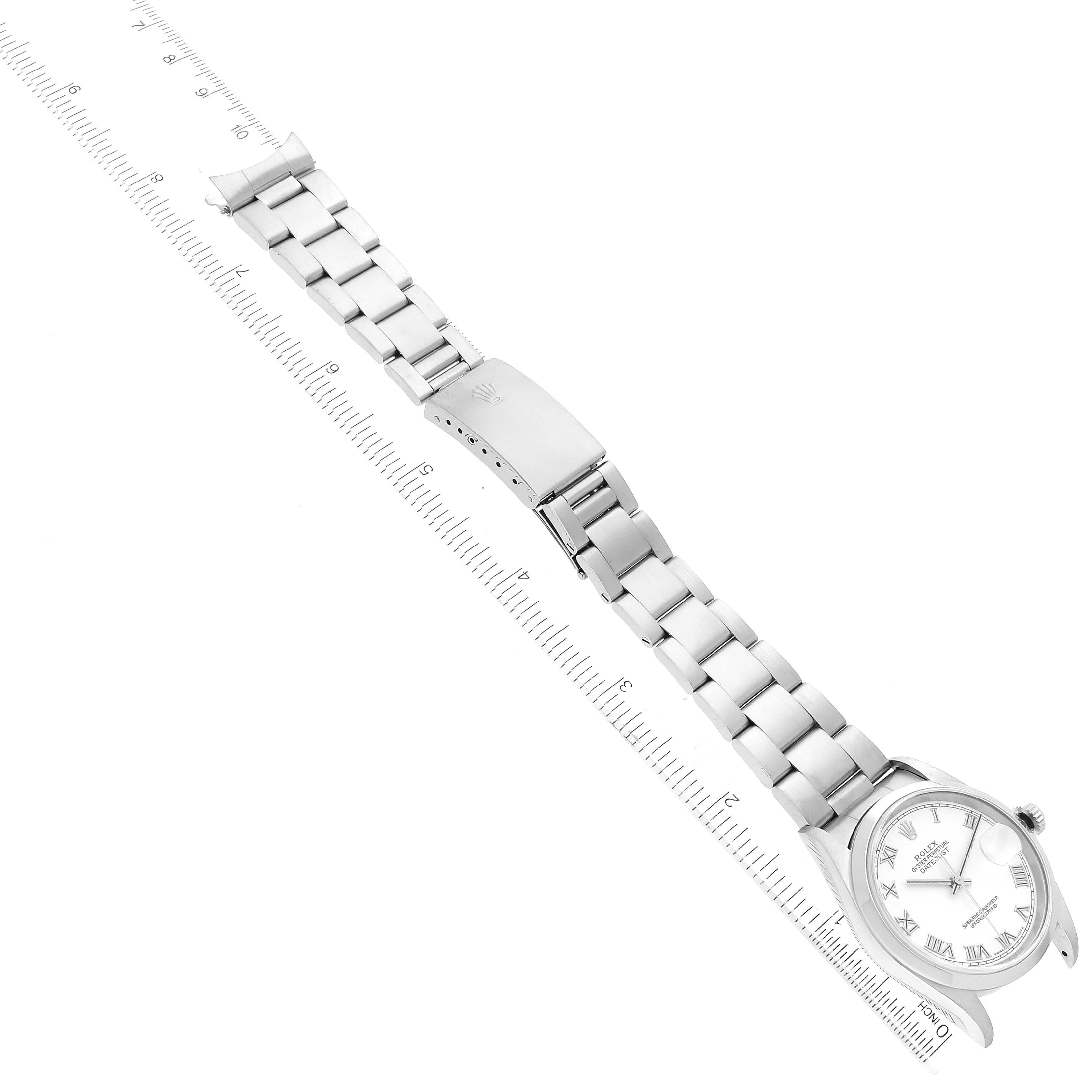 This image of a Rolex Datejust 16200 Men's Stainless Steel White Dial 16200 Men's Stainless Steel White Dial watch shows a top-down view focusing on the bracelet and clasp, placed next to a ruler.