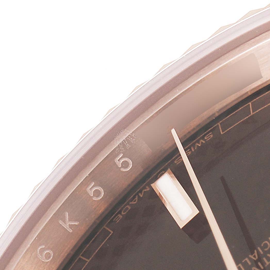 This close-up image of a Rolex President 228235 Men's Rose Gold Brown Dial 228235 Men's Rose Gold Brown Dial model watch shows part of the bezel, dial, and hour marker.