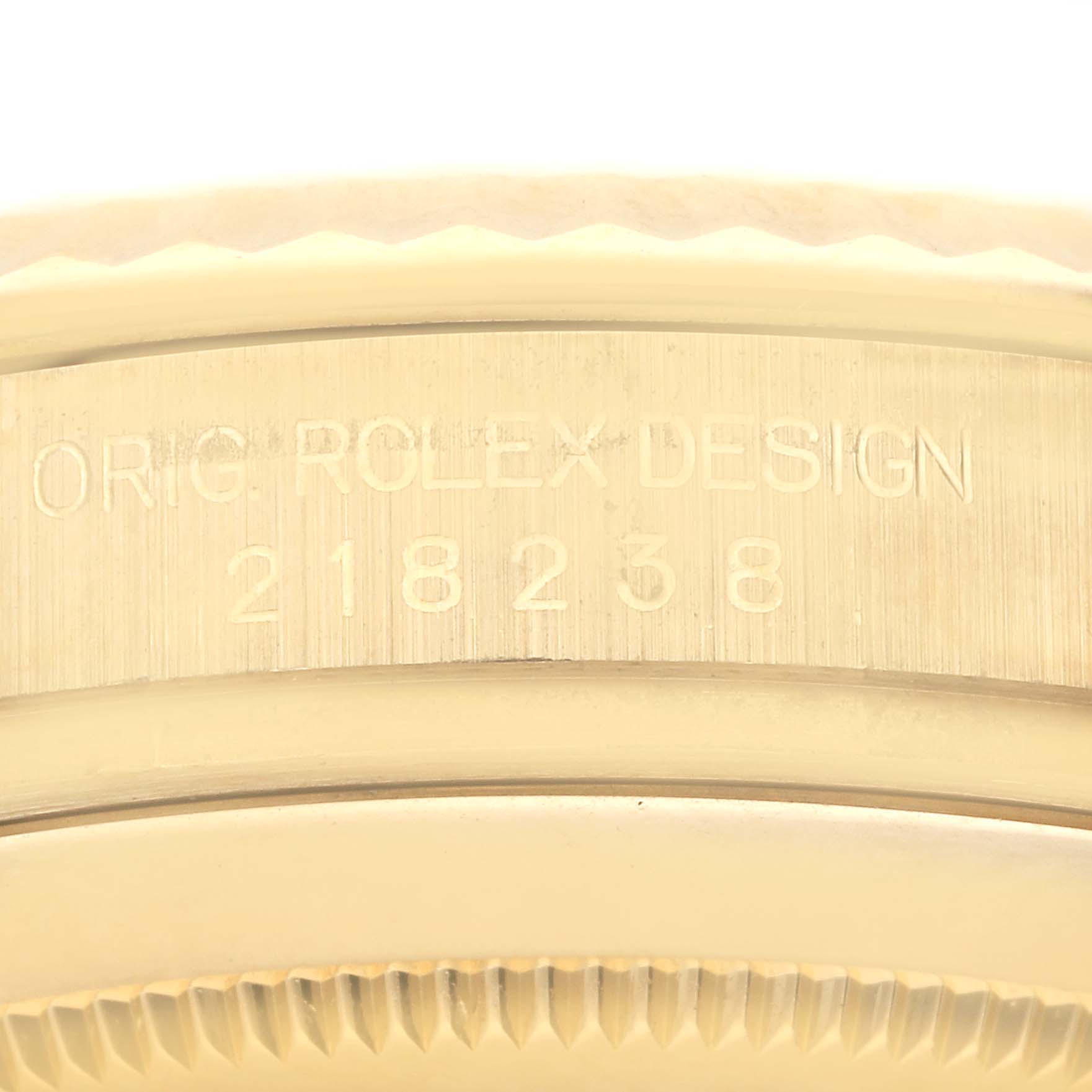 This image shows the engraved model number and part of the fluted bezel of a Rolex President 218238 Men's Yellow Gold Champagne Dial 218238 Men's Yellow Gold Champagne Dial watch.