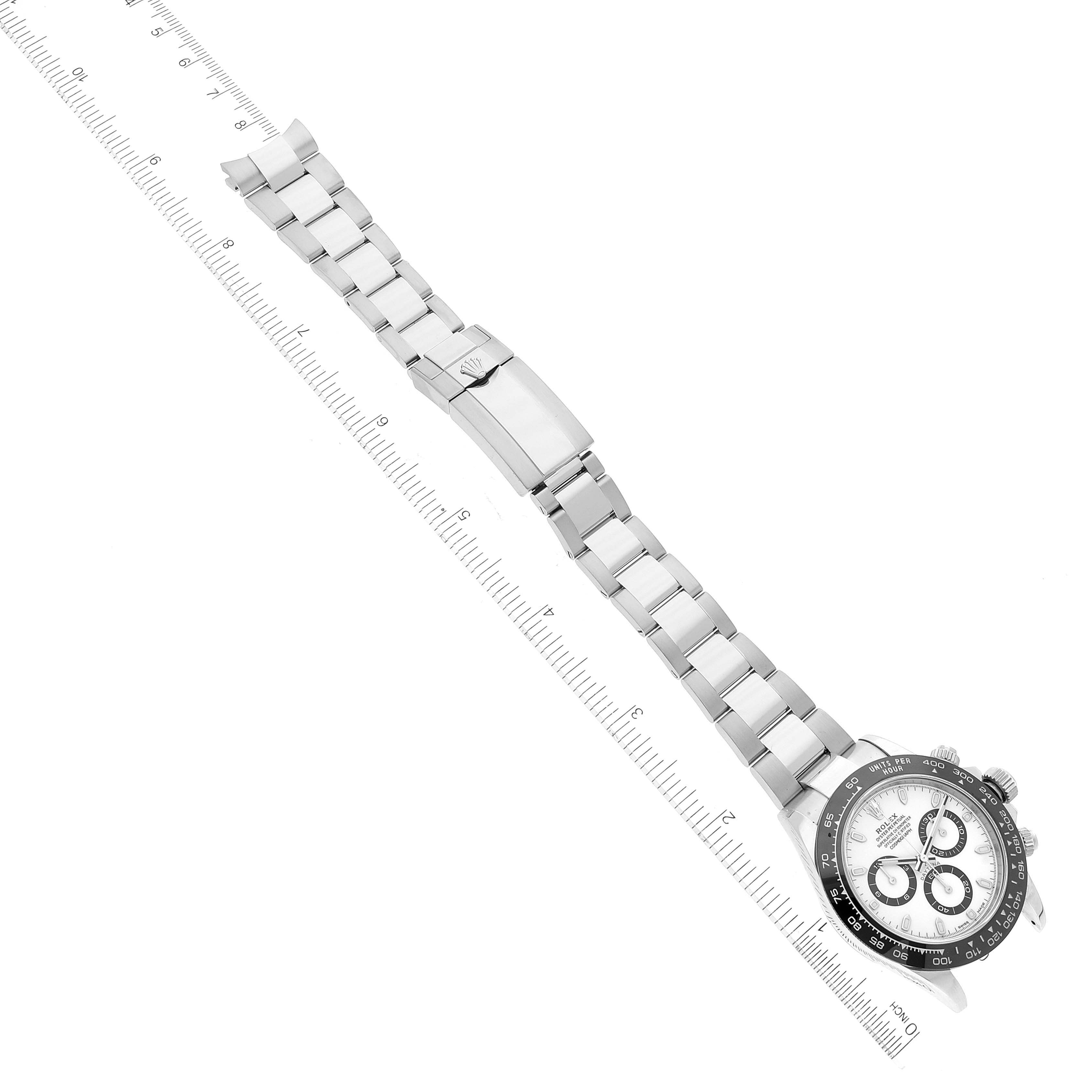 The image shows a Rolex Daytona 116500 Men's Stainless Steel White Dial 116500 Men's Stainless Steel White Dial watch, featuring its full stainless steel bracelet, clasp, and partially visible dial and bezel at an angled top-down view.