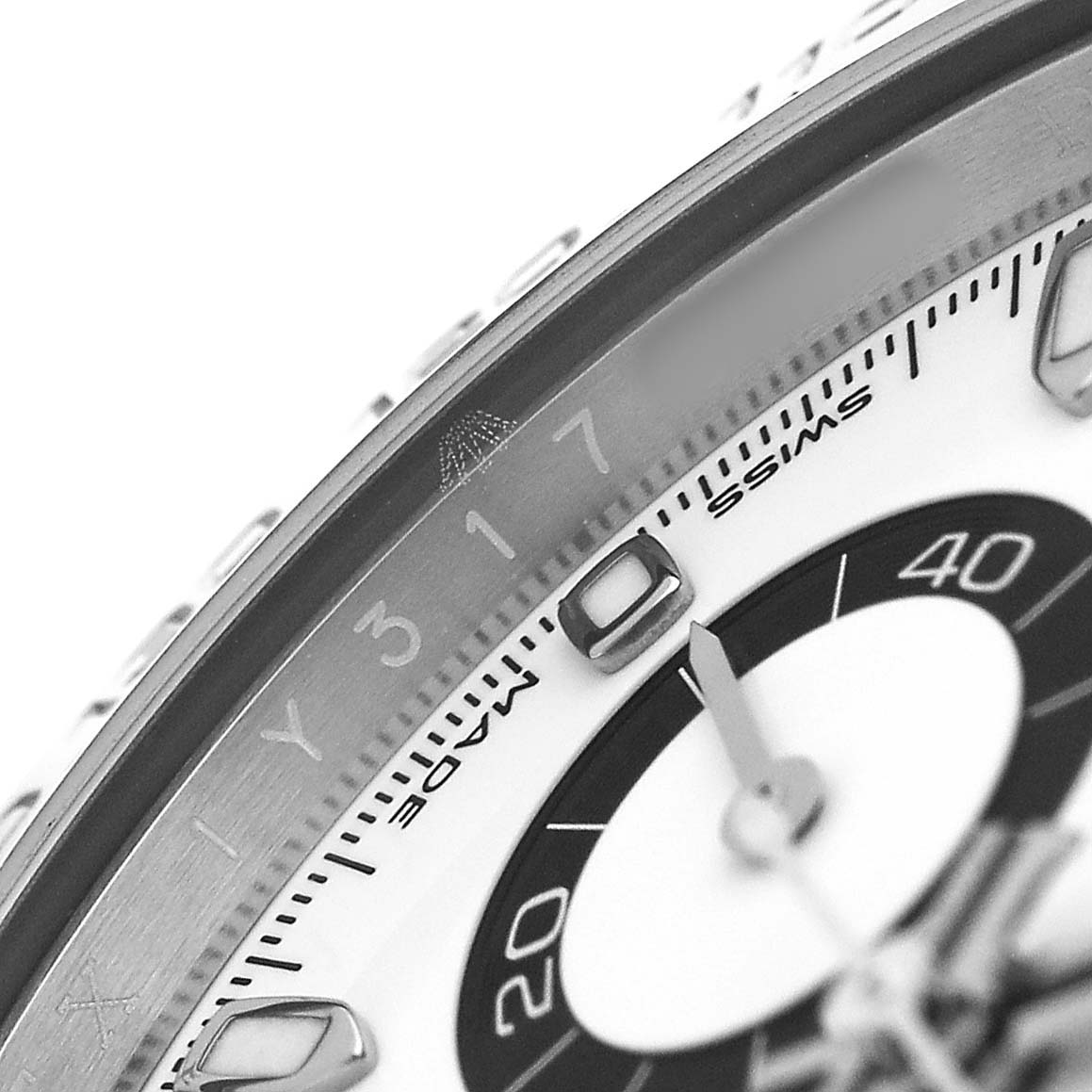 The image shows a close-up of the bezel and part of the dial of a Rolex Daytona 116500LN Men's Stainless Steel White Dial watch, highlighting the chronograph scale and markers.