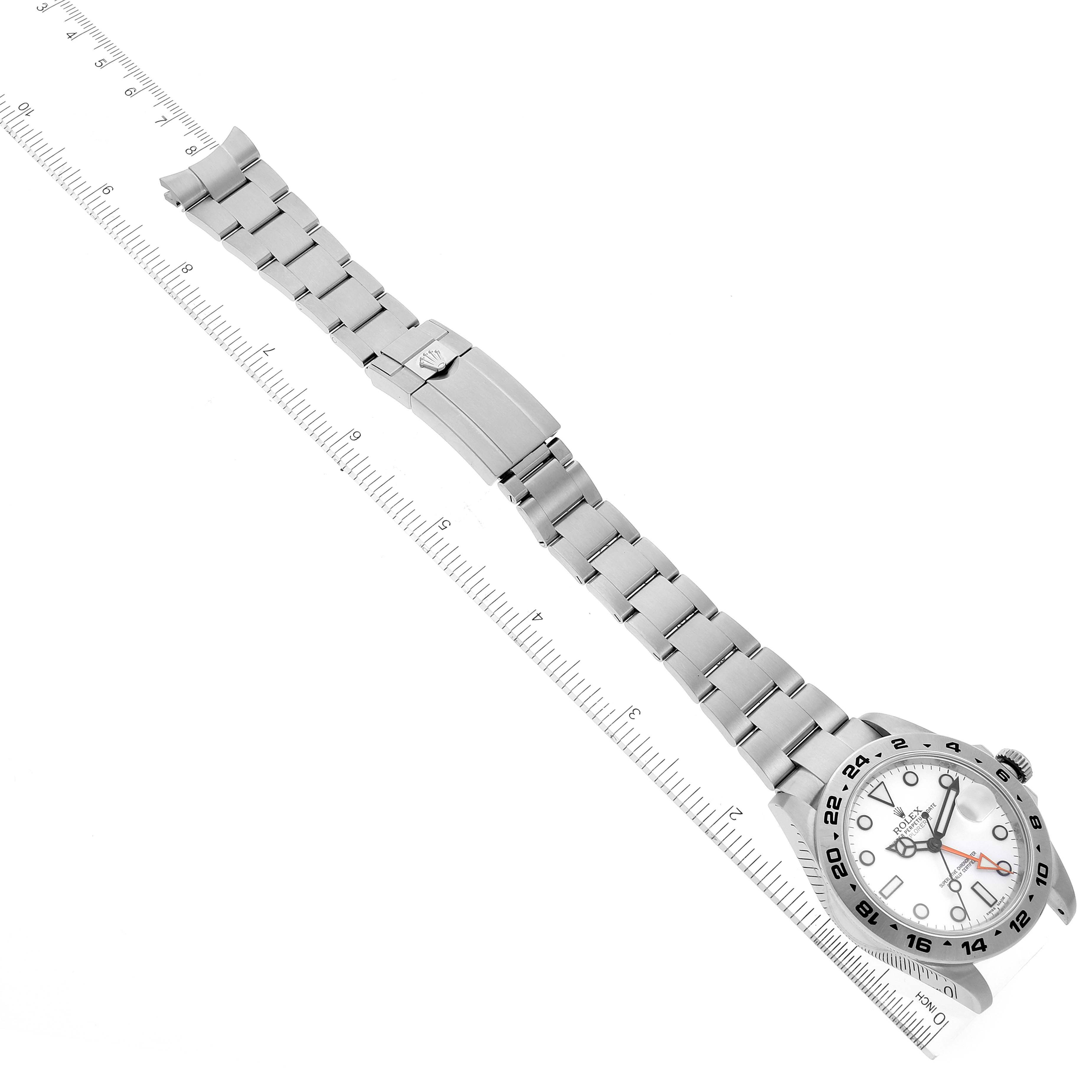 The image shows a Rolex Explorer 216570 Men's Stainless Steel White Dial 216570 Men's Stainless Steel White Dial watch laid flat with a ruler alongside, highlighting the watch band and face.