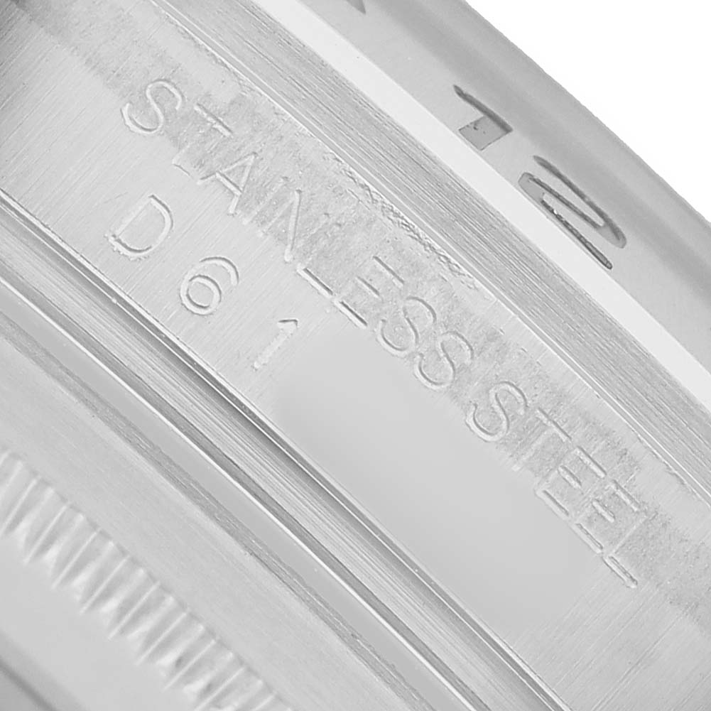 The image shows a close-up of the side engraving on a Rolex Explorer 16570 T Men's Stainless Steel Black Dial model watch, indicating "STAINLESS STEEL."