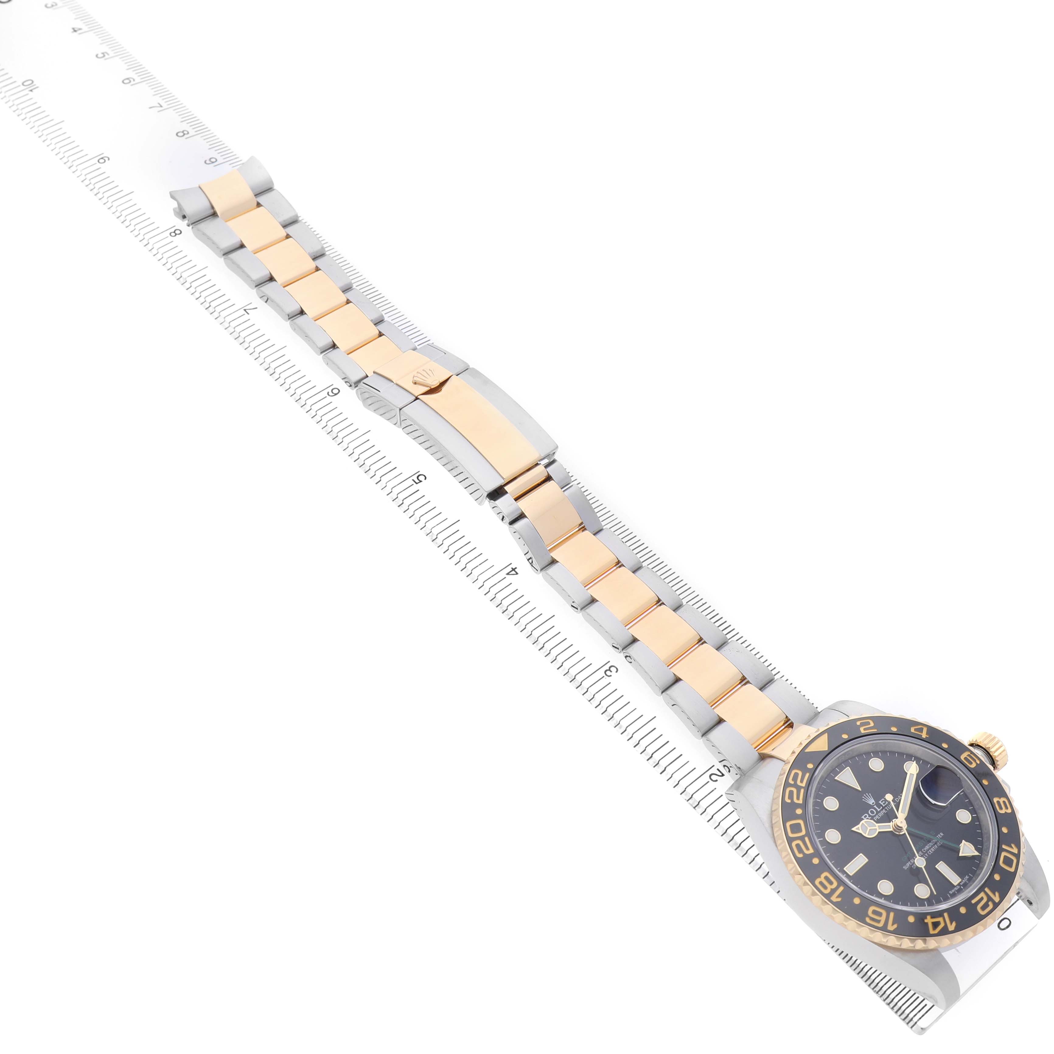 The Rolex GMT-Master M116713LN Men's Steel and Gold (two tone) Black Dial watch is shown at a top-down angle, including the face, bezel, bracelet, and clasp.