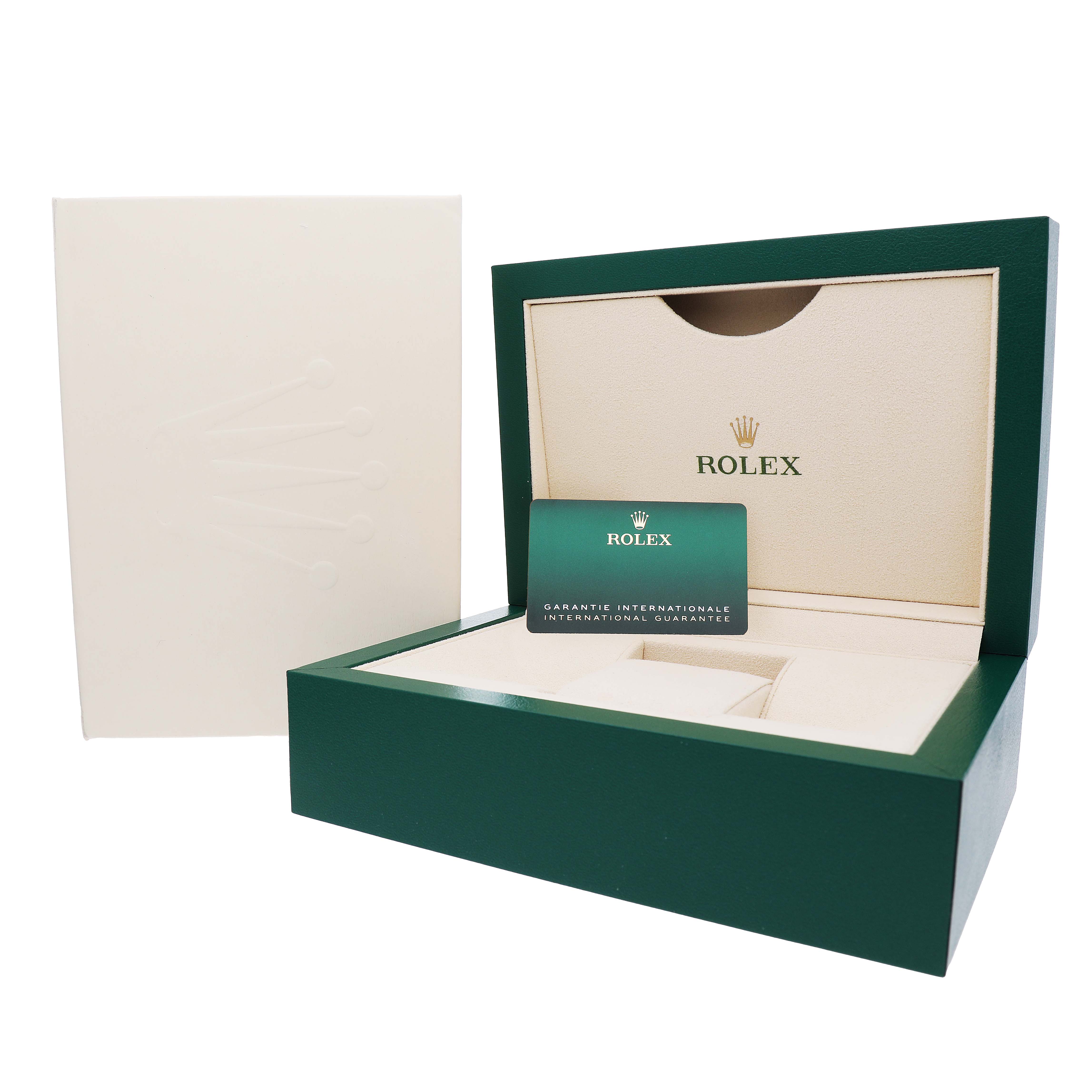 The image shows the open presentation box and guarantee card for a Rolex Land-Dweller watch, viewed from the front.