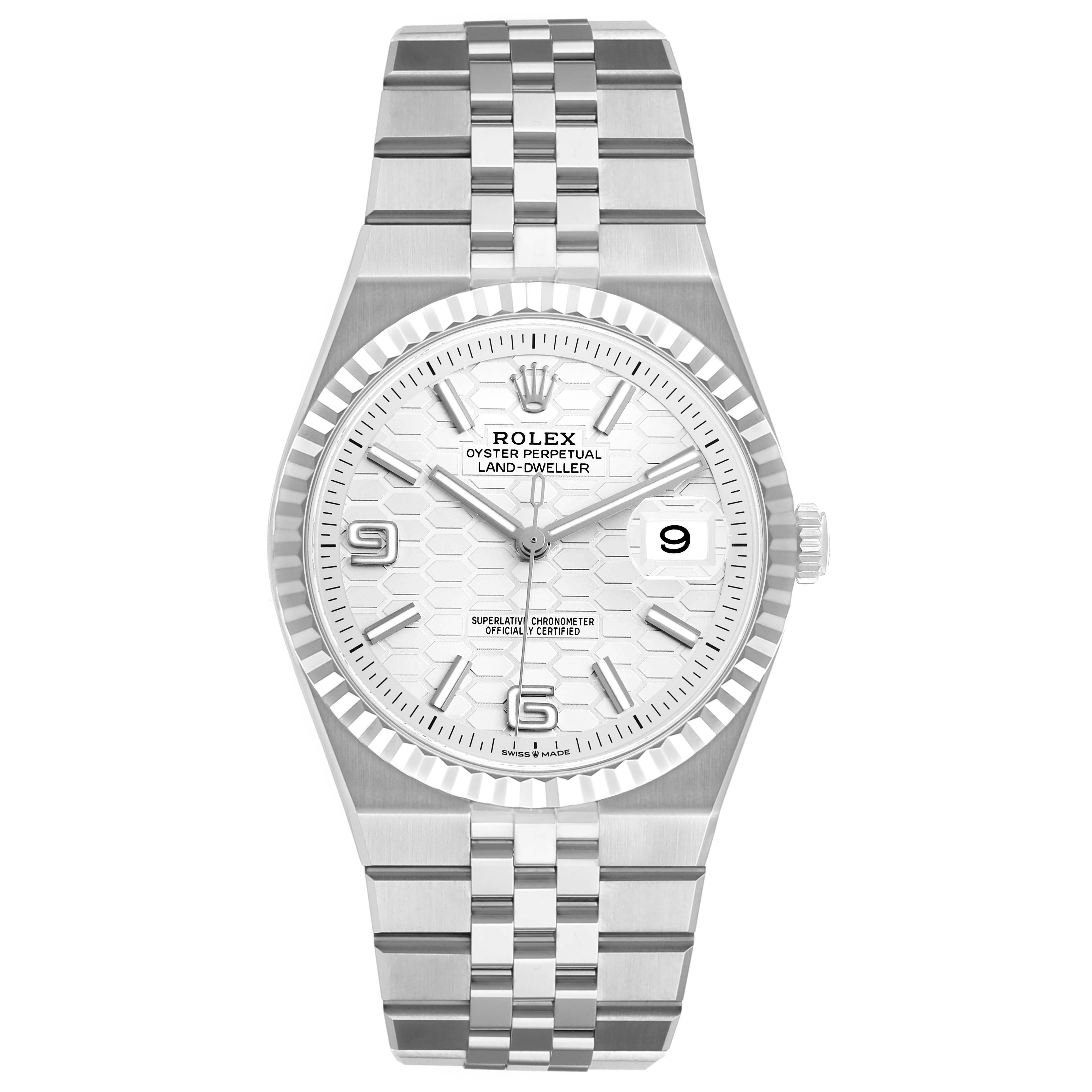 The Rolex Land-Dweller watch is shown from a top-down angle, displaying the face, bezel, and full bracelet.