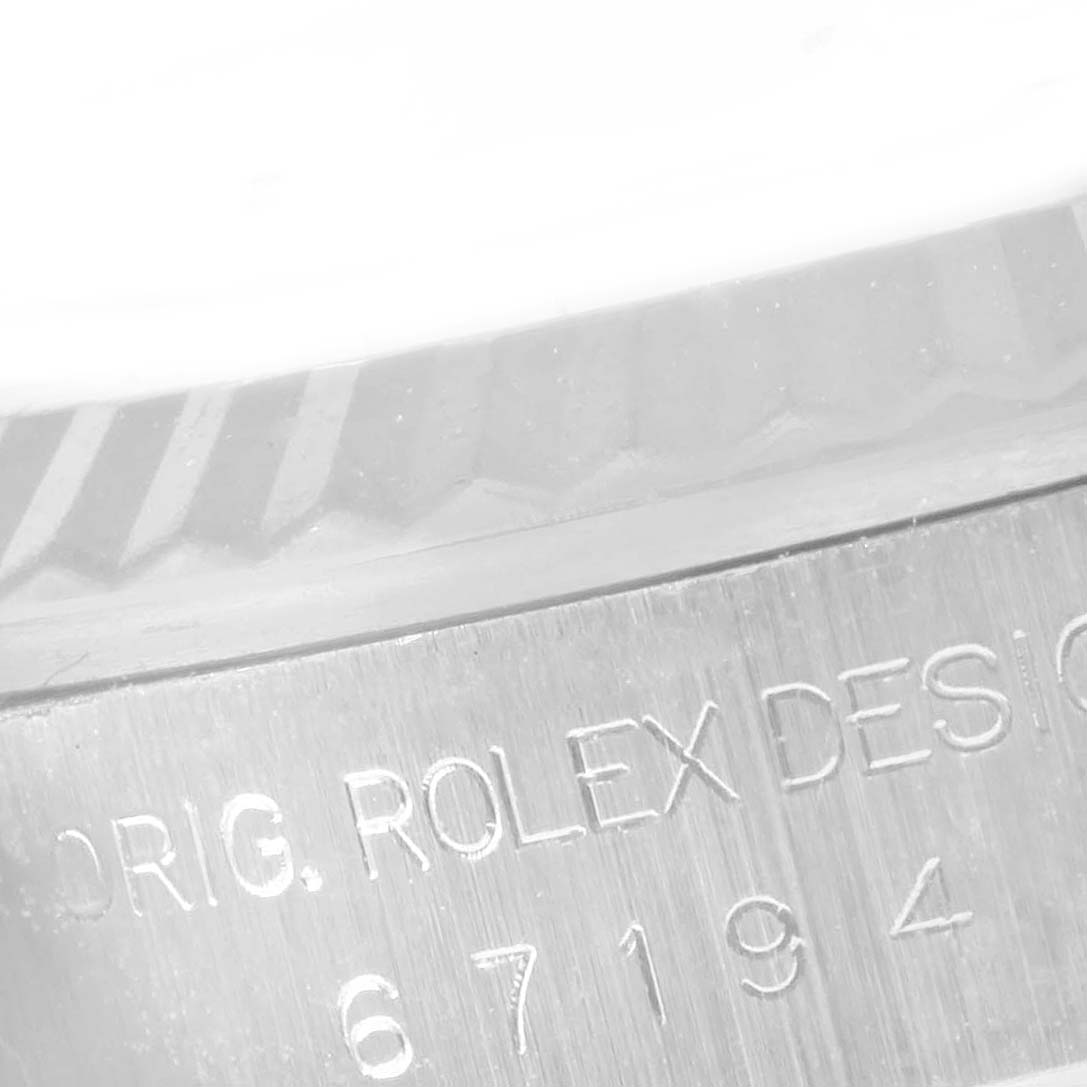 This is a close-up shot of the engraving on the side of the case of a Rolex Oyster Perpetual 67194 Women's Stainless Steel Silver Dial 67194 Women's Stainless Steel Silver Dial watch.