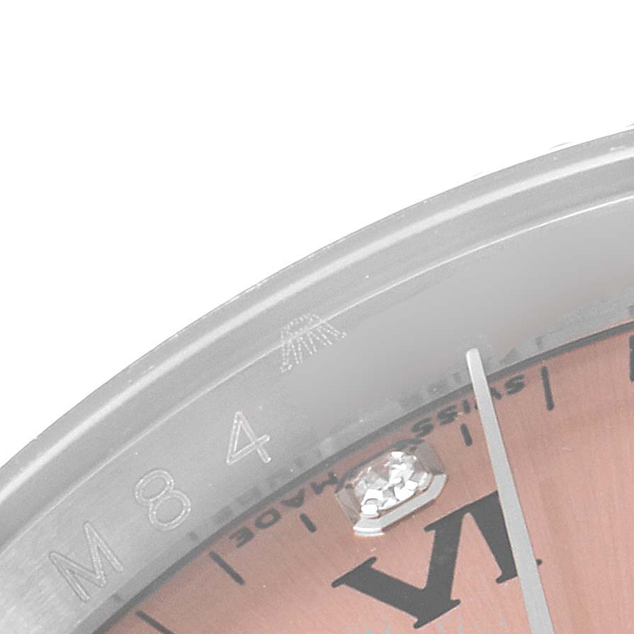 The image shows a close-up angle of the Rolex Oyster Perpetual 116034 Men
s Stainless Steel Pink Dial 116034 Men
s Stainless Steel Pink Dial watch, highlighting the bezel, a portion of the dial, and a diamond marker.