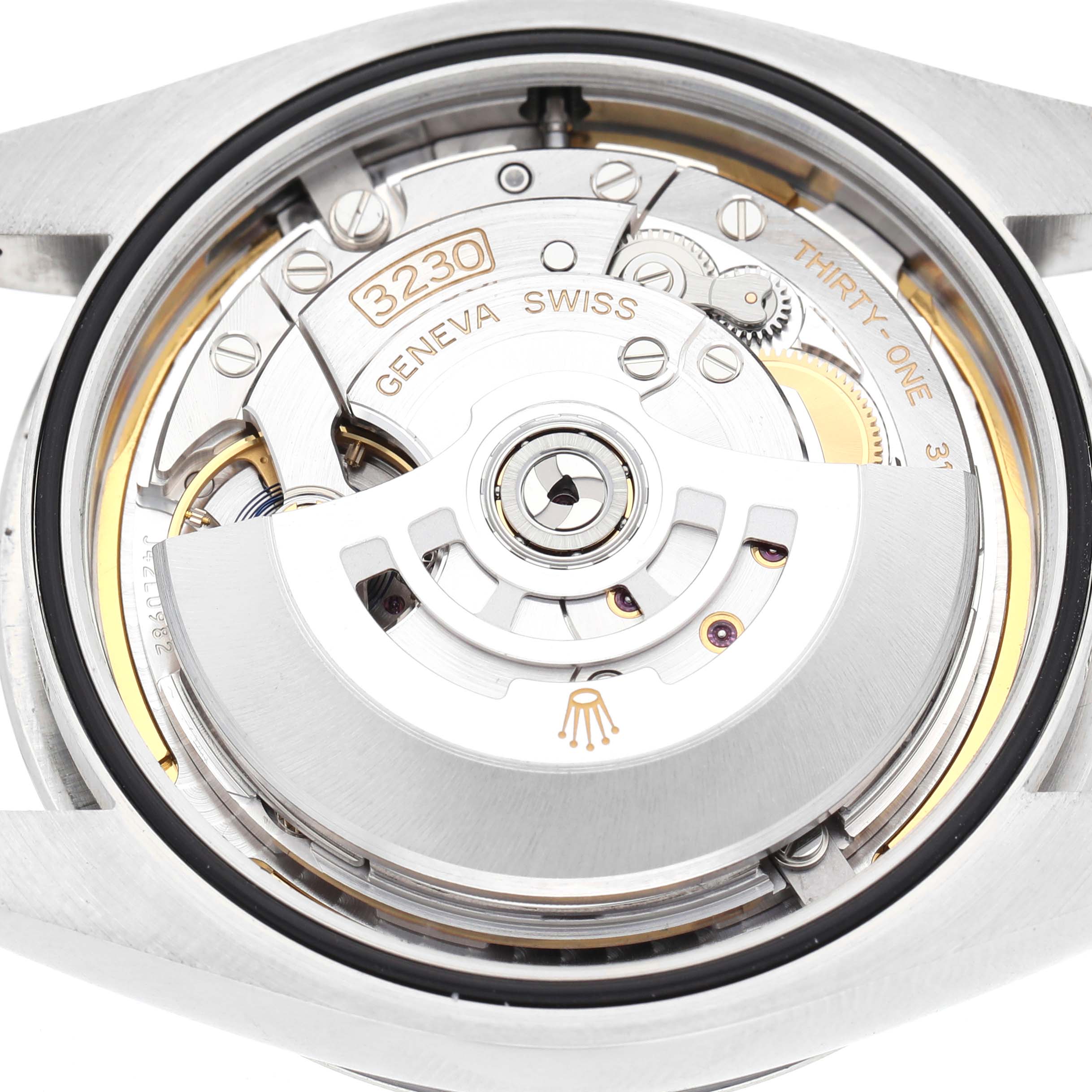 The image shows the movement of a Rolex Oyster Perpetual 124300 Men's Stainless Steel Blue Dial, viewed from the back, displaying its intricate internal mechanism.