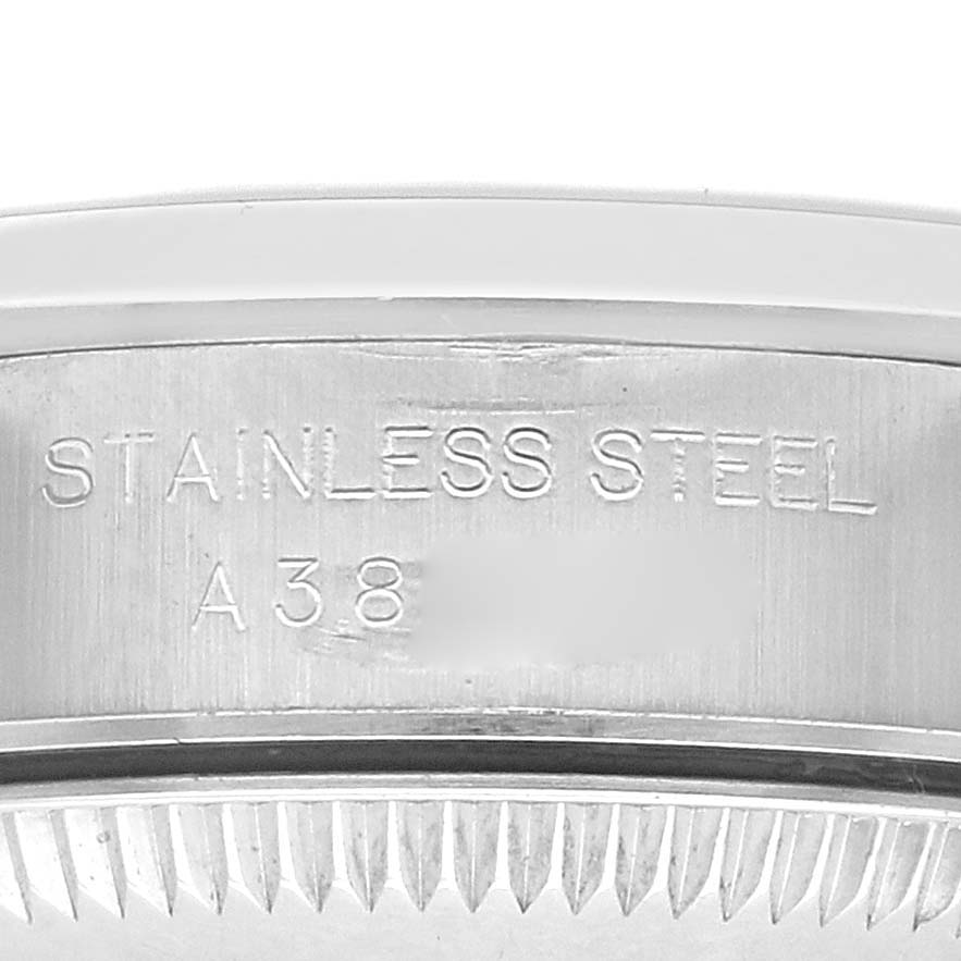 The image shows a close-up of the Rolex Oyster Perpetual 76080 Women
s Stainless Steel Black Dial 76080 Women
s Stainless Steel Black Dial watch case back with "STAINLESS STEEL" engraving.