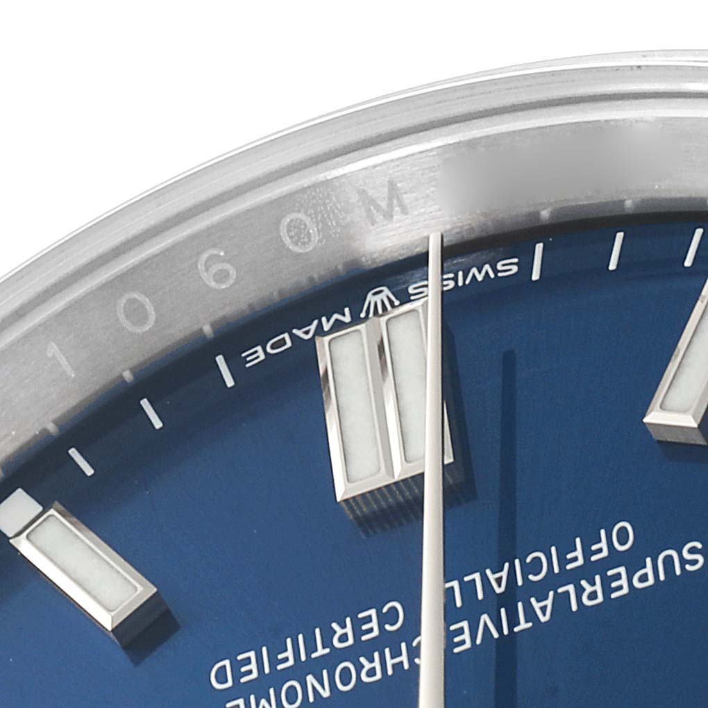 A close-up of the Rolex Oyster Perpetual 126000 Men's Stainless Steel Blue Dial 126000 Men's Stainless Steel Blue Dial's blue dial, showing the markers, "Swiss Made" text, and part of the watch's minute hand.