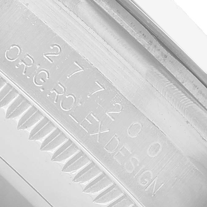 The image shows a close-up of the engraved bezel edge of a Rolex Oyster Perpetual 277200 Women's Stainless Steel Blue Dial watch, featuring serial numbers.