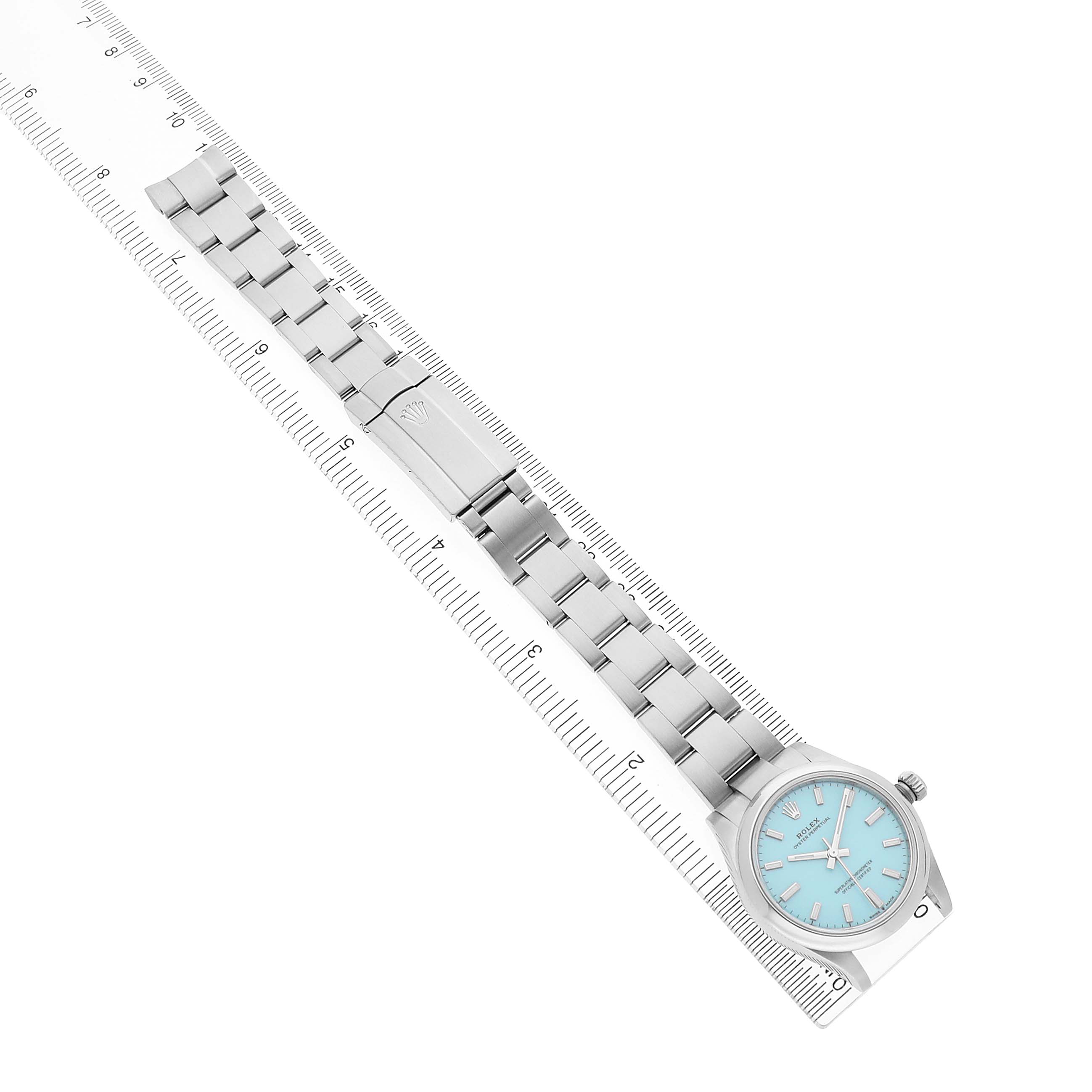 The Rolex Oyster Perpetual 277200 Women's Stainless Steel Blue Dial watch is shown from a top view, featuring the case, bracelet, and clasp aligned with a ruler.