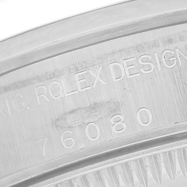 The image shows a close-up of the Rolex Oyster Perpetual 76080 Women
s Stainless Steel Silver Dial 76080 Women
s Stainless Steel Silver Dial
s case engraving displaying the model number.