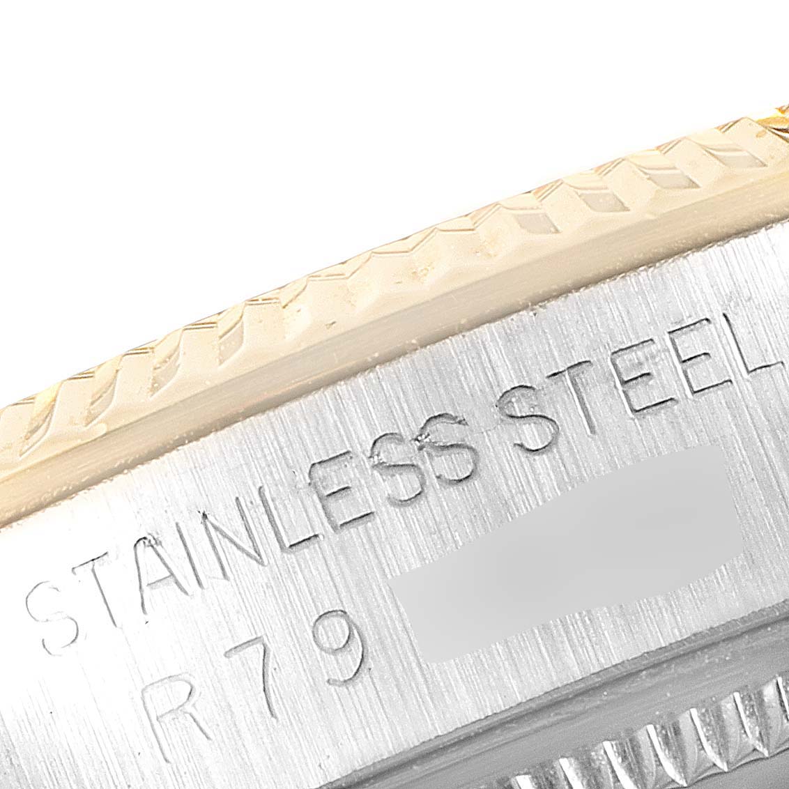 This image shows a close-up view of the side engraving on a Rolex Oyster Perpetual 1005 Men's Steel and Gold (two tone) Champagne Dial 1005 Men's Steel and Gold (two tone) Champagne Dial watch, highlighting the "Stainless Steel" text.