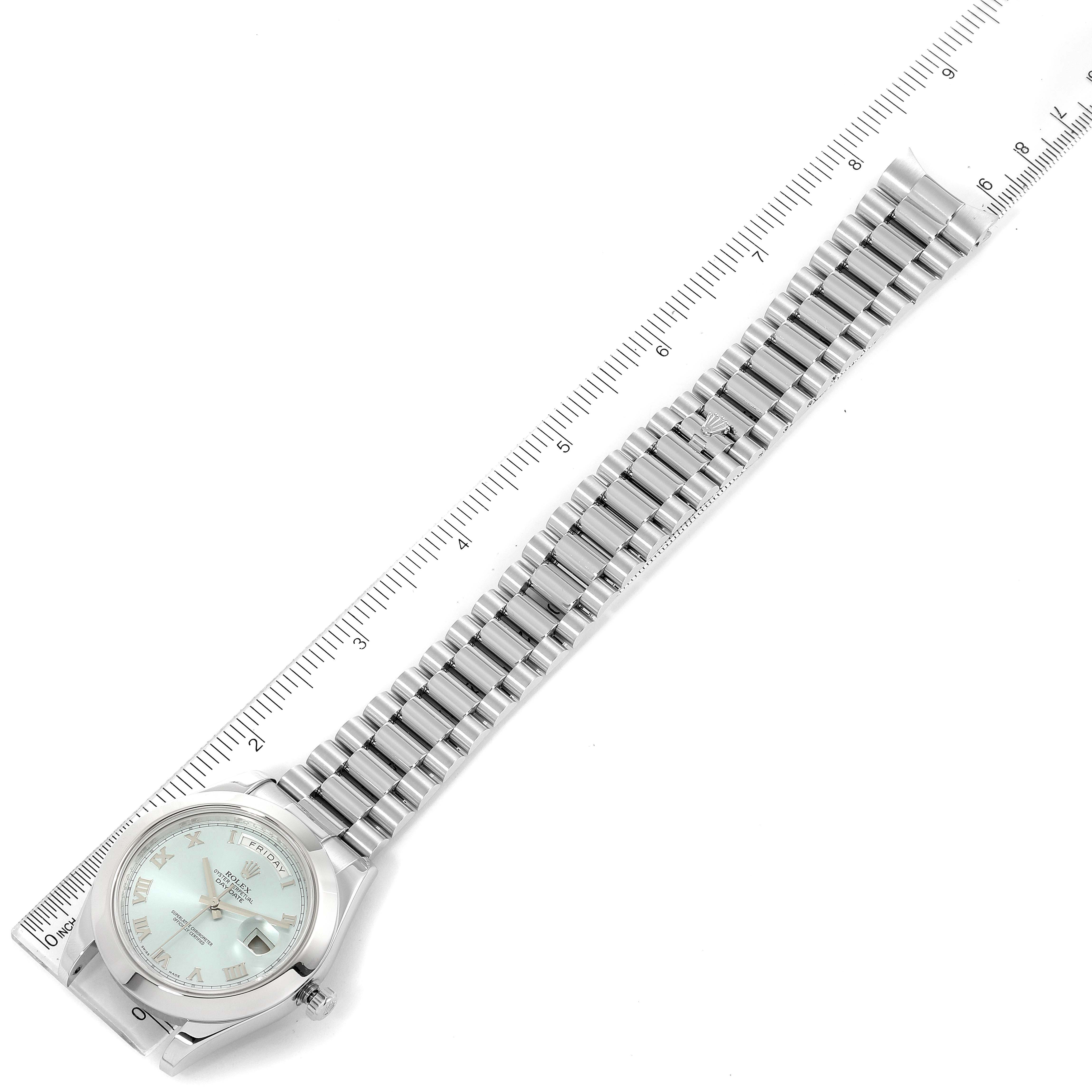 The Rolex President 218206 Men's Platinum Blue Dial 218206 Men's Platinum Blue Dial watch is shown from a top-down angle with a ruler beside it, showcasing the band and face.