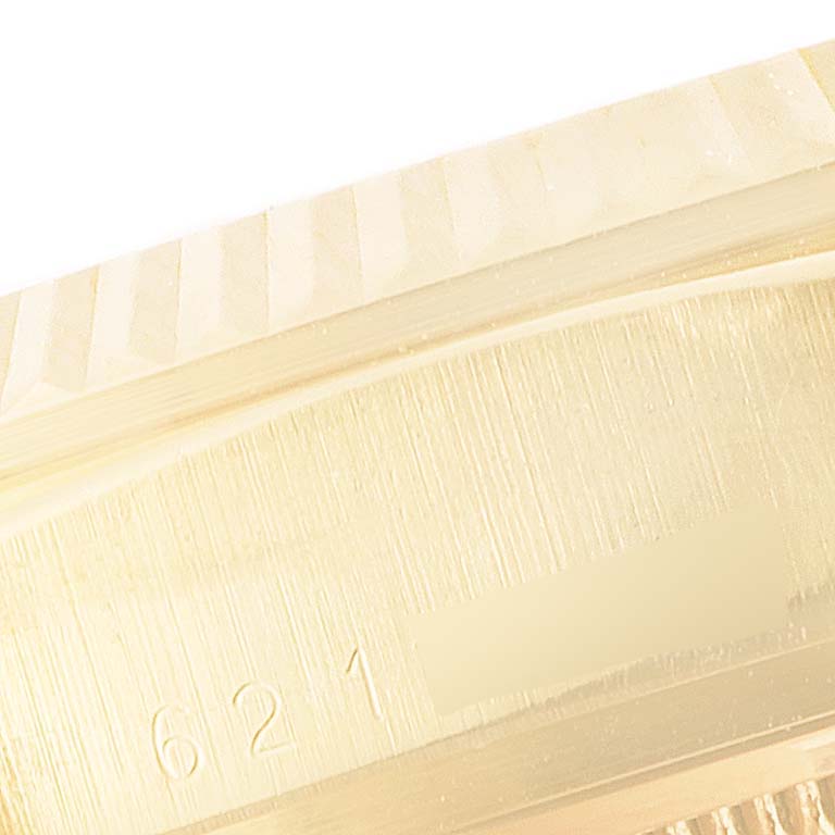 This close-up of a Rolex President 18038 Men's Yellow Gold Champagne Dial 18038 Men's Yellow Gold Champagne Dial model shows part of the watch case with visible engravings.
