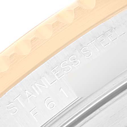 This close-up image of a Rolex Submariner 16613 Men's Steel and Gold (two tone) Black Dial 16613 Men's Steel and Gold (two tone) Black Dial watch shows the edge of the bezel and part of the case with "STAINLESS STEEL" engraving.