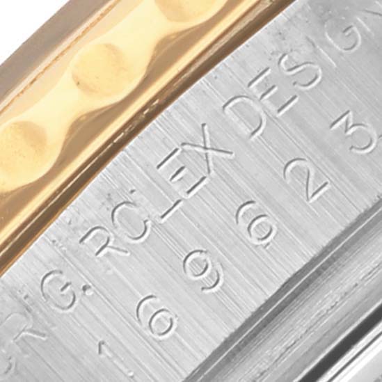 The image shows a close-up of the side of the Rolex Yacht-Master 169623 Women
s Steel and Gold (two tone) Mother of Pearl Dial 169623 Women
s Steel and Gold (two tone) Mother of Pearl Dial, focusing on the case with engravings and gold bezel edge.