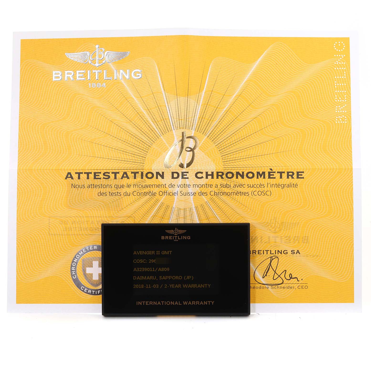 The image shows the Breitling Avenger A3239011 Men's Stainless Steel Mother of Pearl Dial A3239011 Men's Stainless Steel Mother of Pearl Dial II GMT warranty card and attestation of chronometer certificate from a frontal angle.