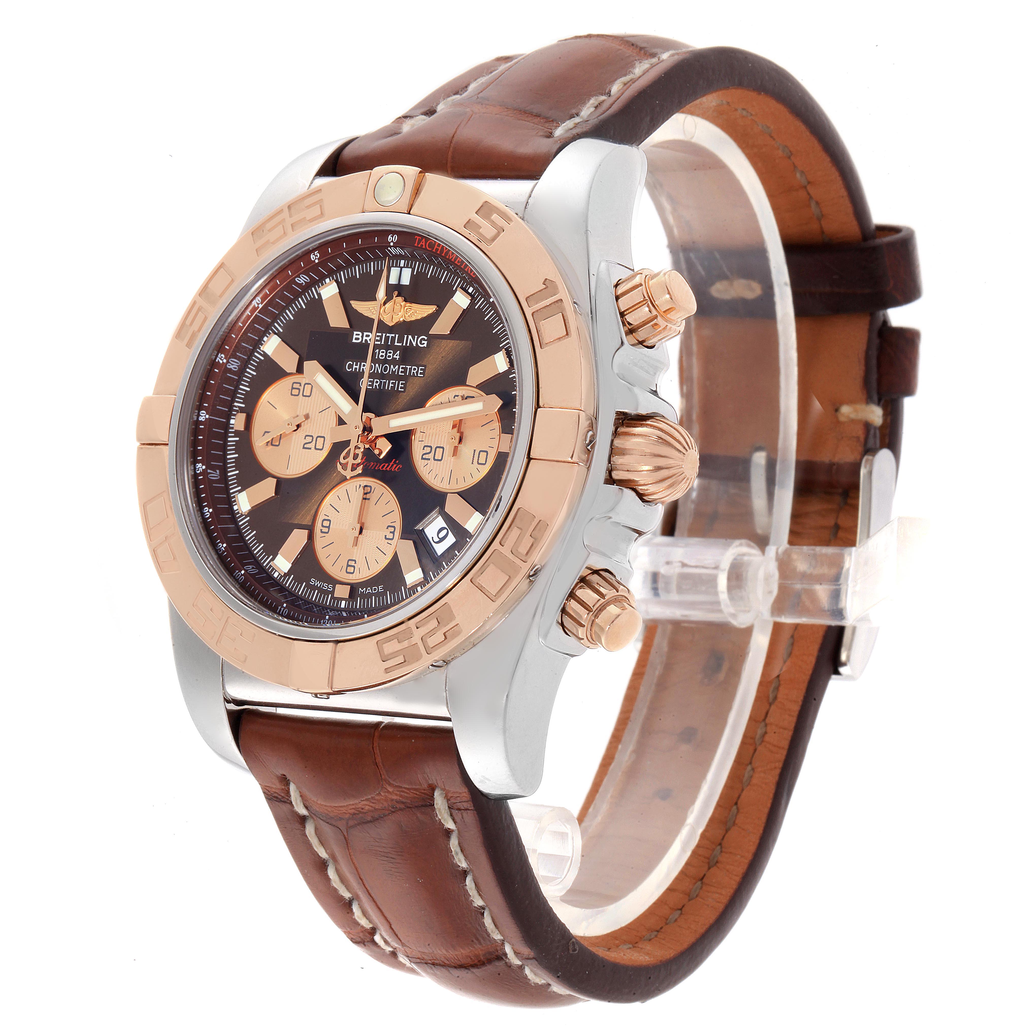 The image shows a side and front angle of a Breitling Chronomat CB0110 Men
s Steel and Gold (two tone) Brown Dial CB0110 Men
s Steel and Gold (two tone) Brown Dial watch with a leather strap and metal case.