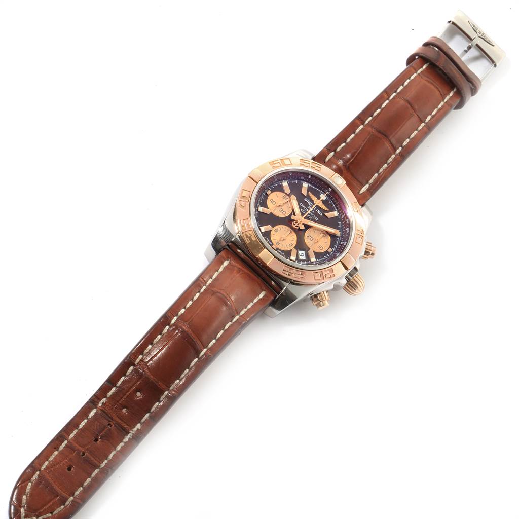 This image shows a Breitling Chronomat CB0110 Men
s Steel and Gold (two tone) Brown Dial CB0110 Men
s Steel and Gold (two tone) Brown Dial watch from a top-down angle, highlighting its face, bezel, and brown leather strap.