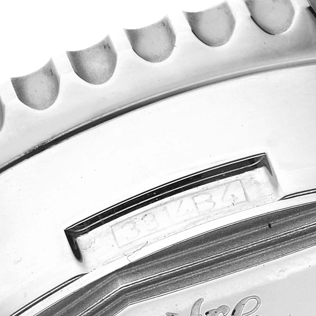 The image shows a close-up of the side and bezel of the Breitling Navitimer AB0127 Men
s Stainless Steel Black Dial AB0127 Men
s Stainless Steel Black Dial watch, highlighting part of the case and a serial number.