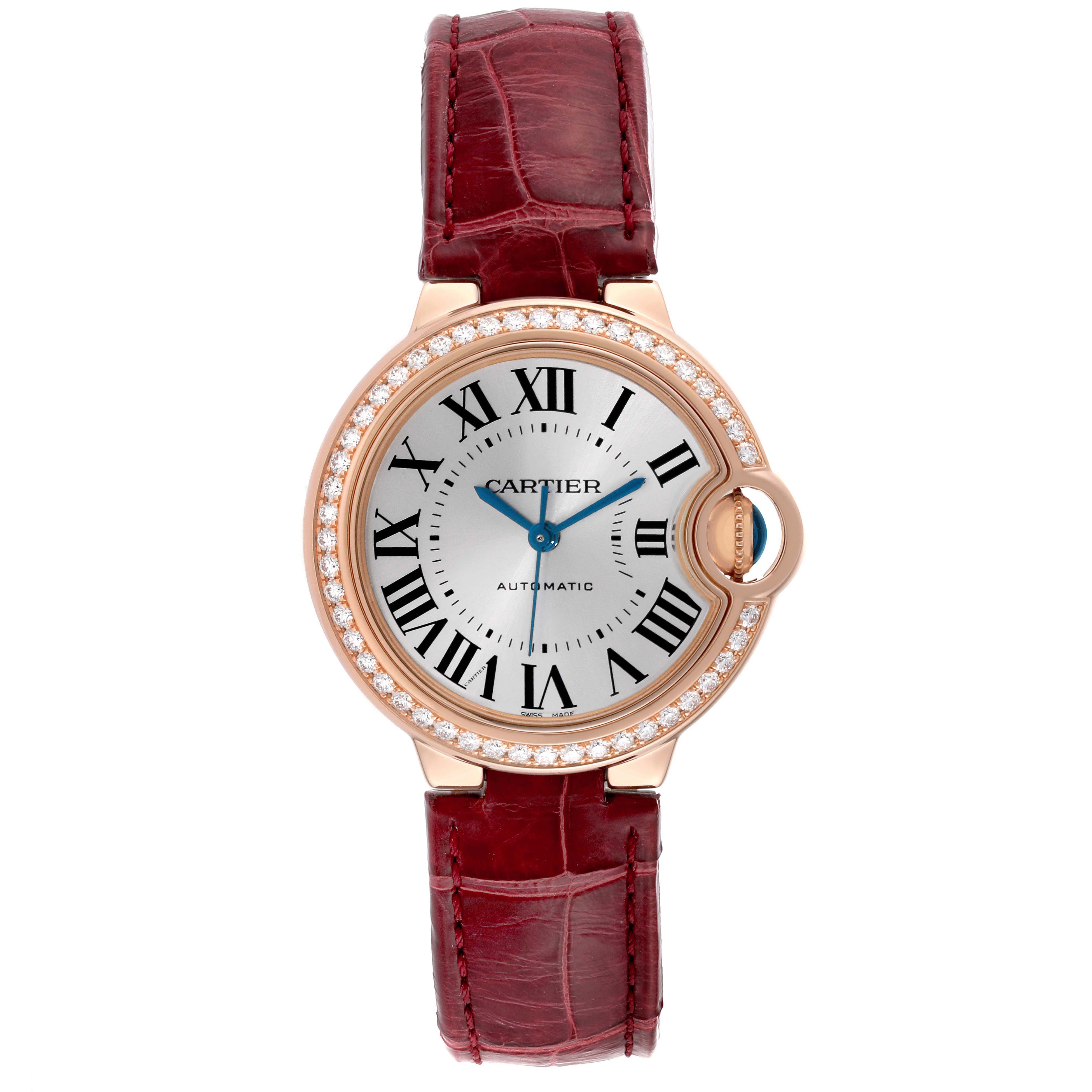 The Cartier Ballon Bleu WJBB0033 Women's Rose Gold Silver Dial watch is shown from a frontal angle, highlighting its circular face, Roman numerals, blue hands, diamond bezel, and red leather strap.