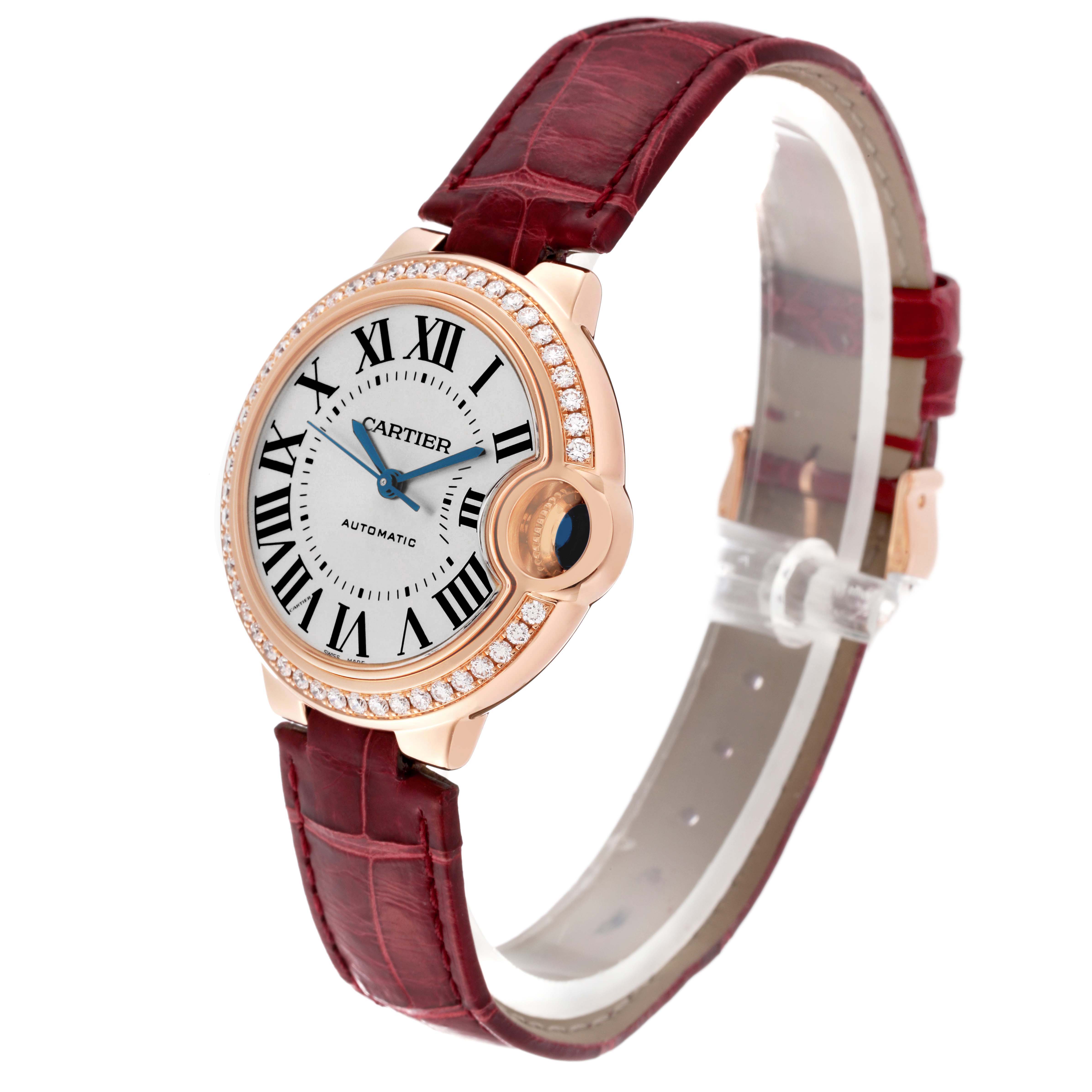 The Cartier Ballon Bleu WJBB0033 Women's Rose Gold Silver Dial watch is shown at a slight angle, highlighting its round face, diamond bezel, and red leather strap.