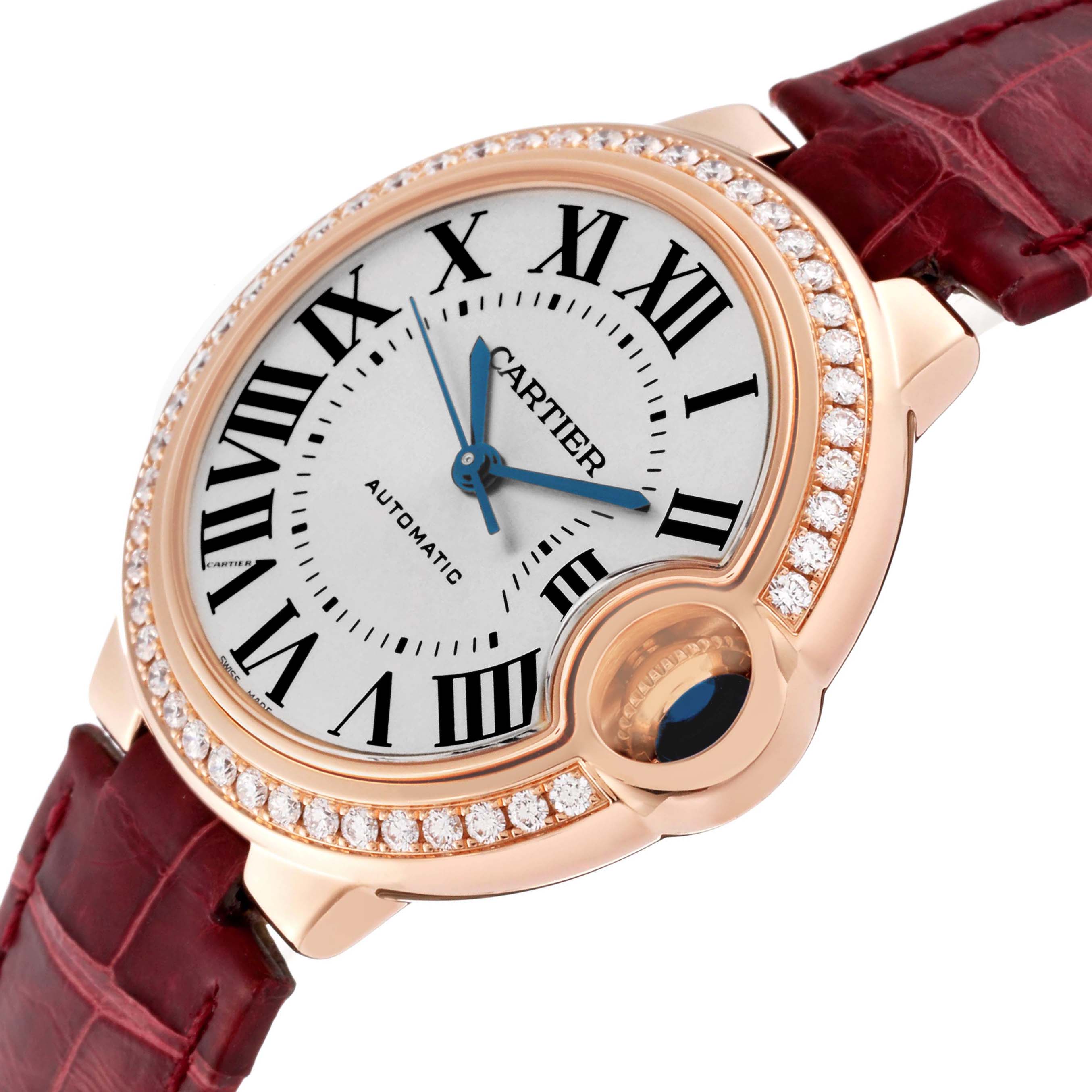 The Cartier Ballon Bleu WJBB0033 Women's Rose Gold Silver Dial watch is shown at an angle highlighting the face, roman numerals, blue hands, diamond bezel, and crown.