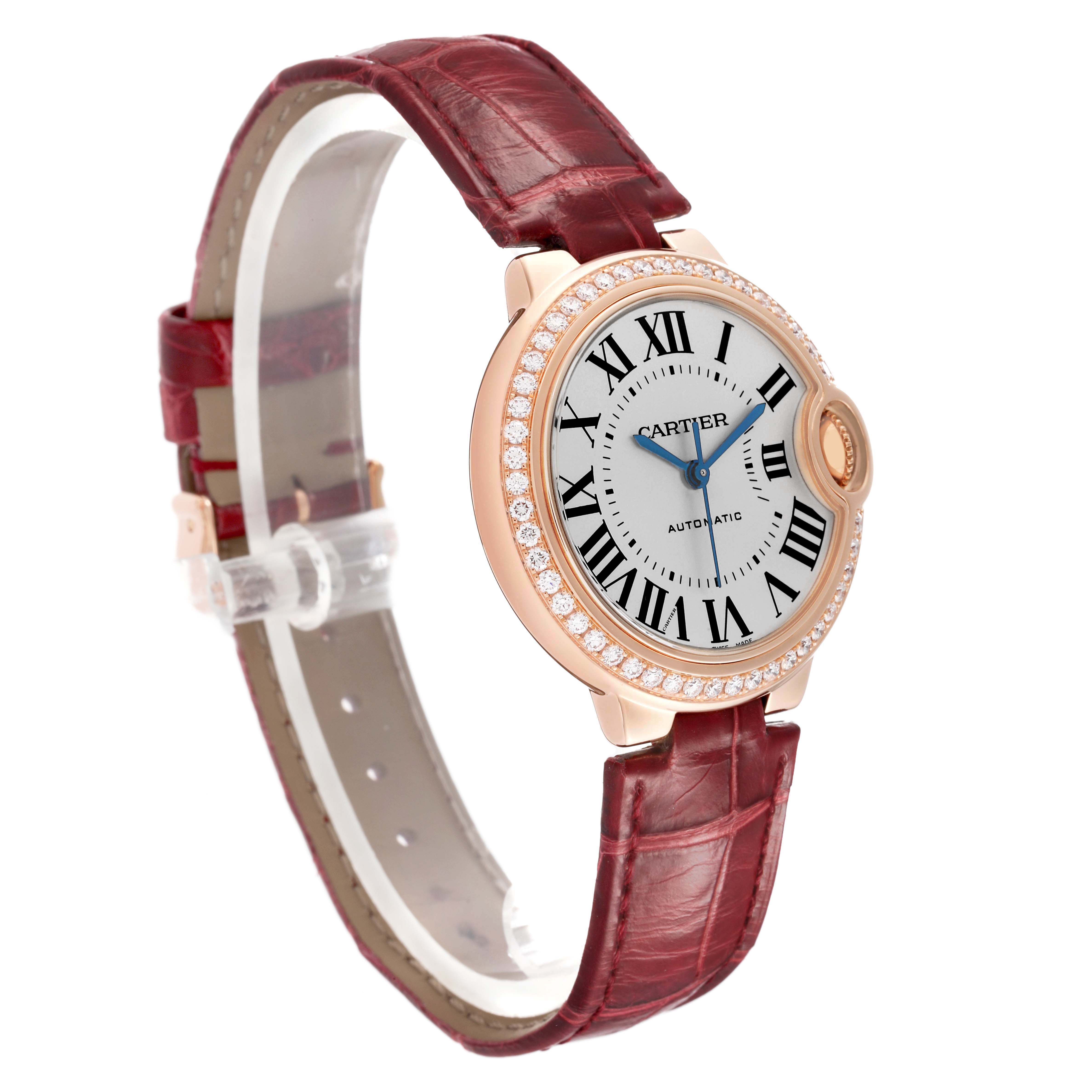 The Cartier Ballon Bleu WJBB0033 Women's Rose Gold Silver Dial watch is shown at a three-quarter angle, highlighting the face, bezel, crown, and red strap.
