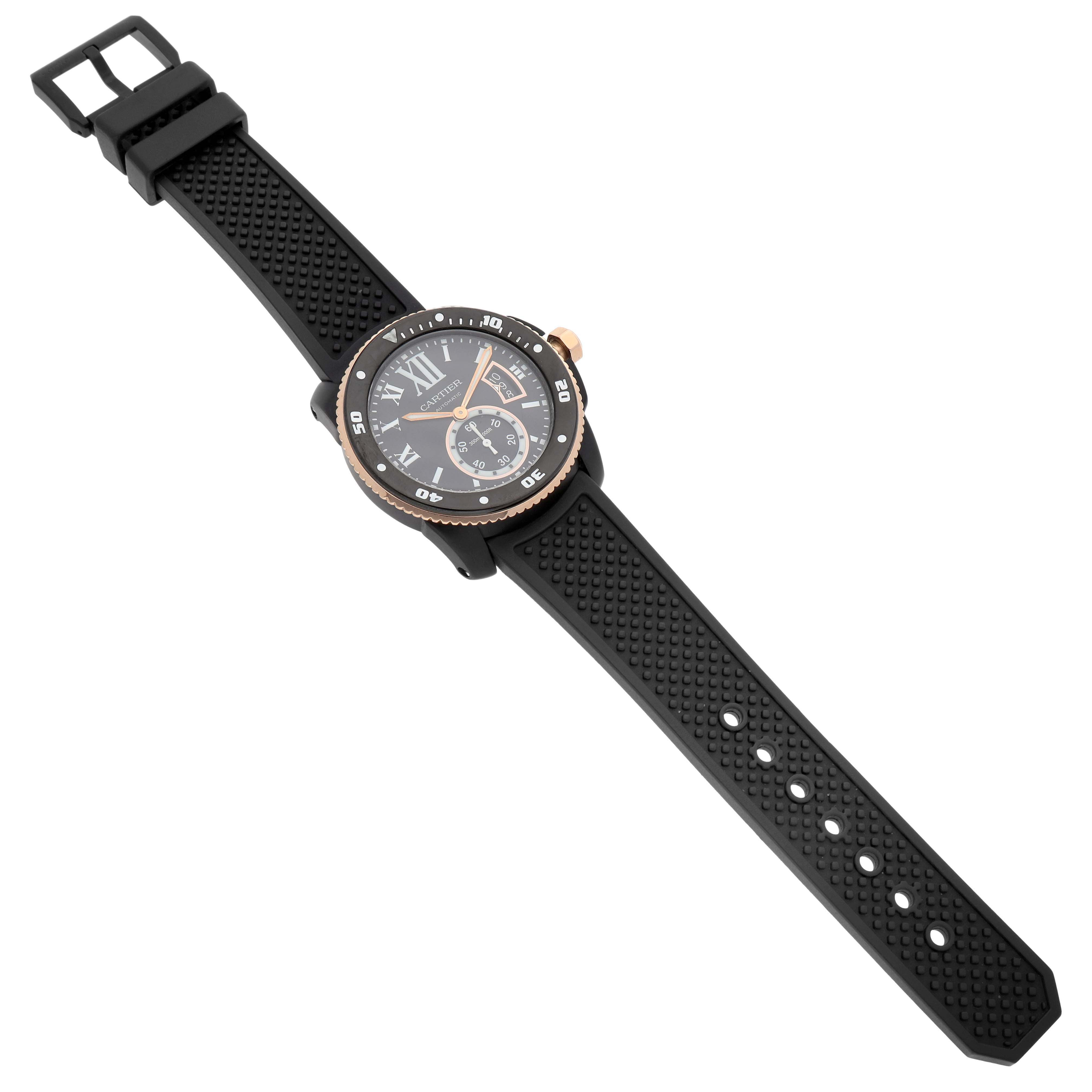 The Calibre de Cartier watch is shown from a high angle, highlighting the face, bezel, crown, and perforated rubber strap.