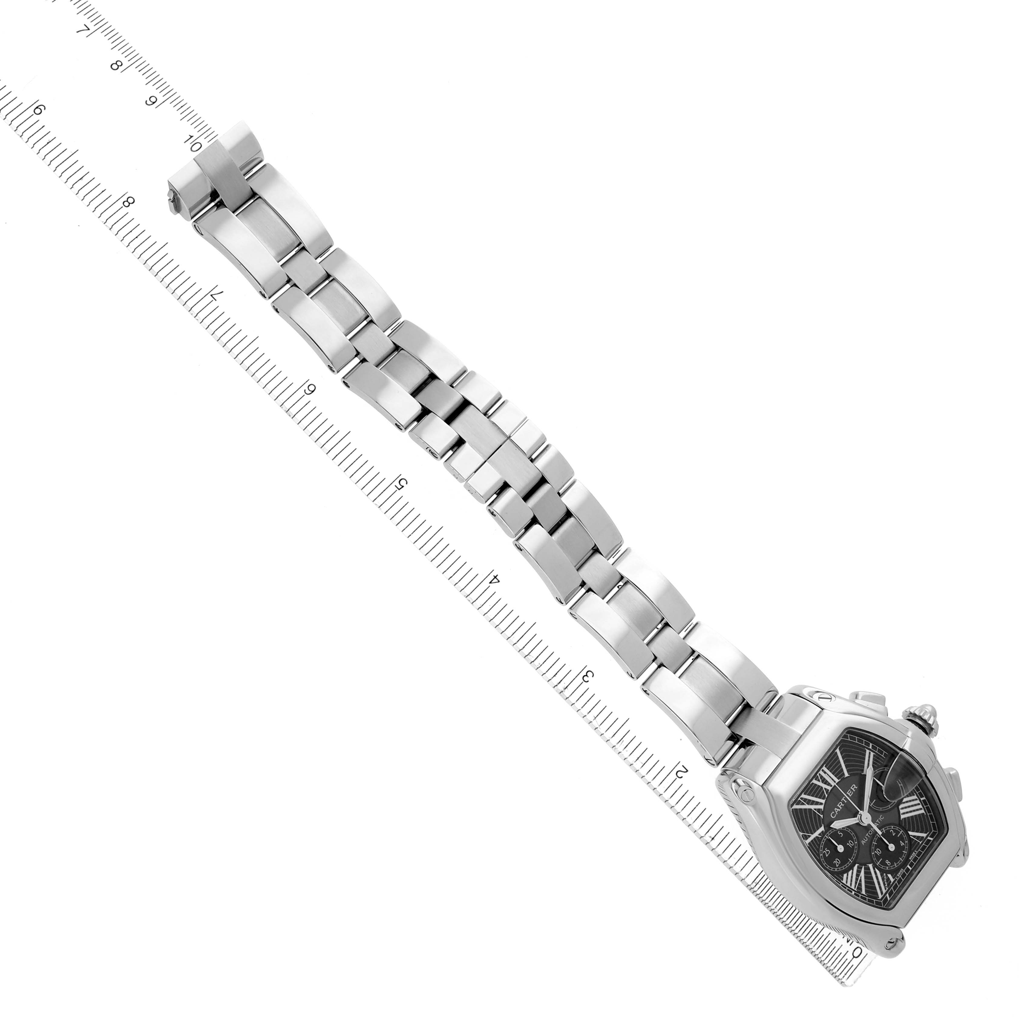 The Cartier Roadster W62020X6 Men
s Stainless Steel Black Dial W62020X6 Men
s Stainless Steel Black Dial watch is shown at a diagonal angle with its bracelet extended alongside a ruler.