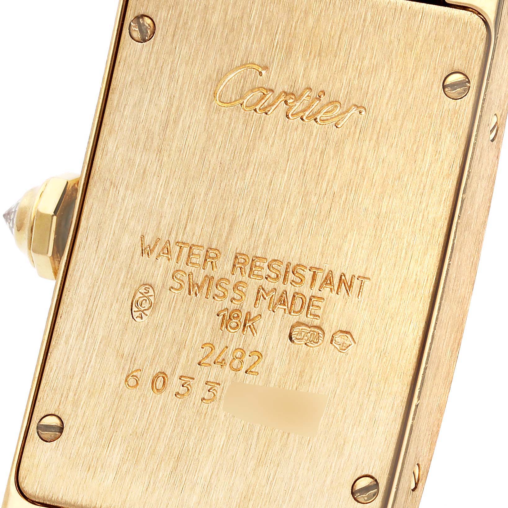 This is the case back of a Cartier Tank Americaine WB701251 Women's Yellow Gold Silver Dial WB701251 Women's Yellow Gold Silver Dial watch, displayed at an angle showing engravings and screws.