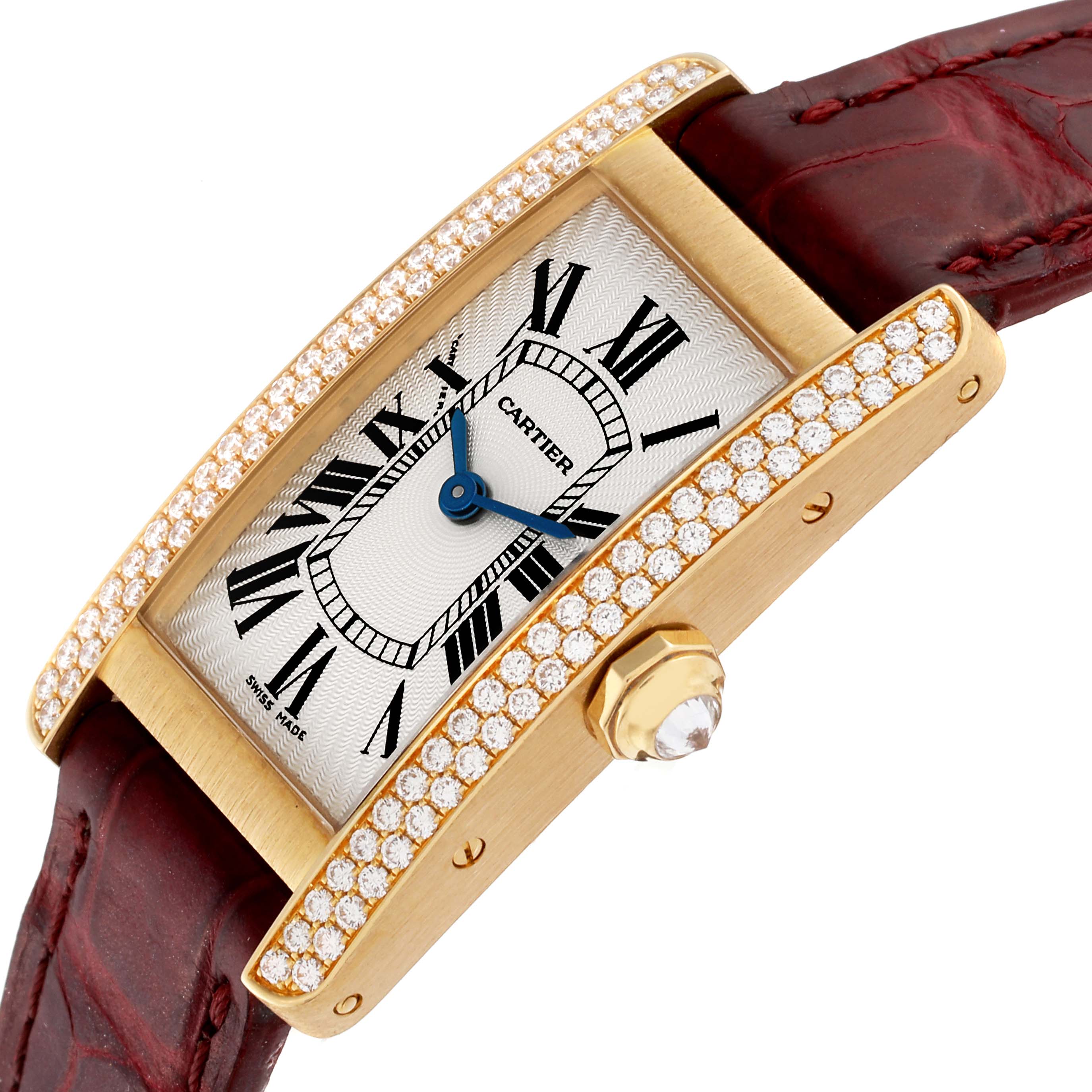 The Cartier Tank Américaine watch is shown at an angled view, highlighting its diamond-studded bezel, roman numeral dial, blue hands, and leather strap.