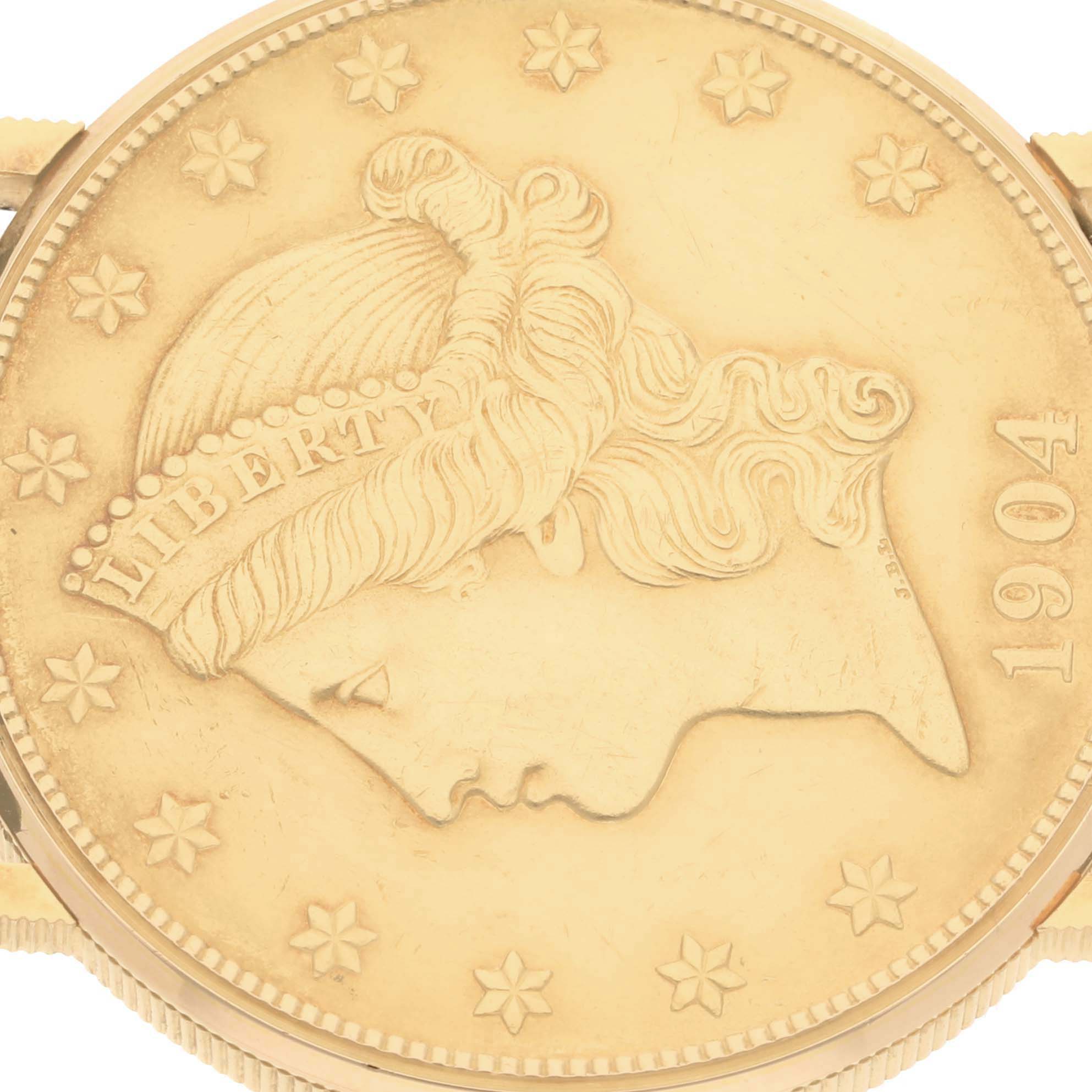 The image shows a close-up of the face of a Corum Coin Watch Men's Yellow Gold Yellow Dial Men's Yellow Gold Yellow Dial model, featuring a detailed coin design from 1904.