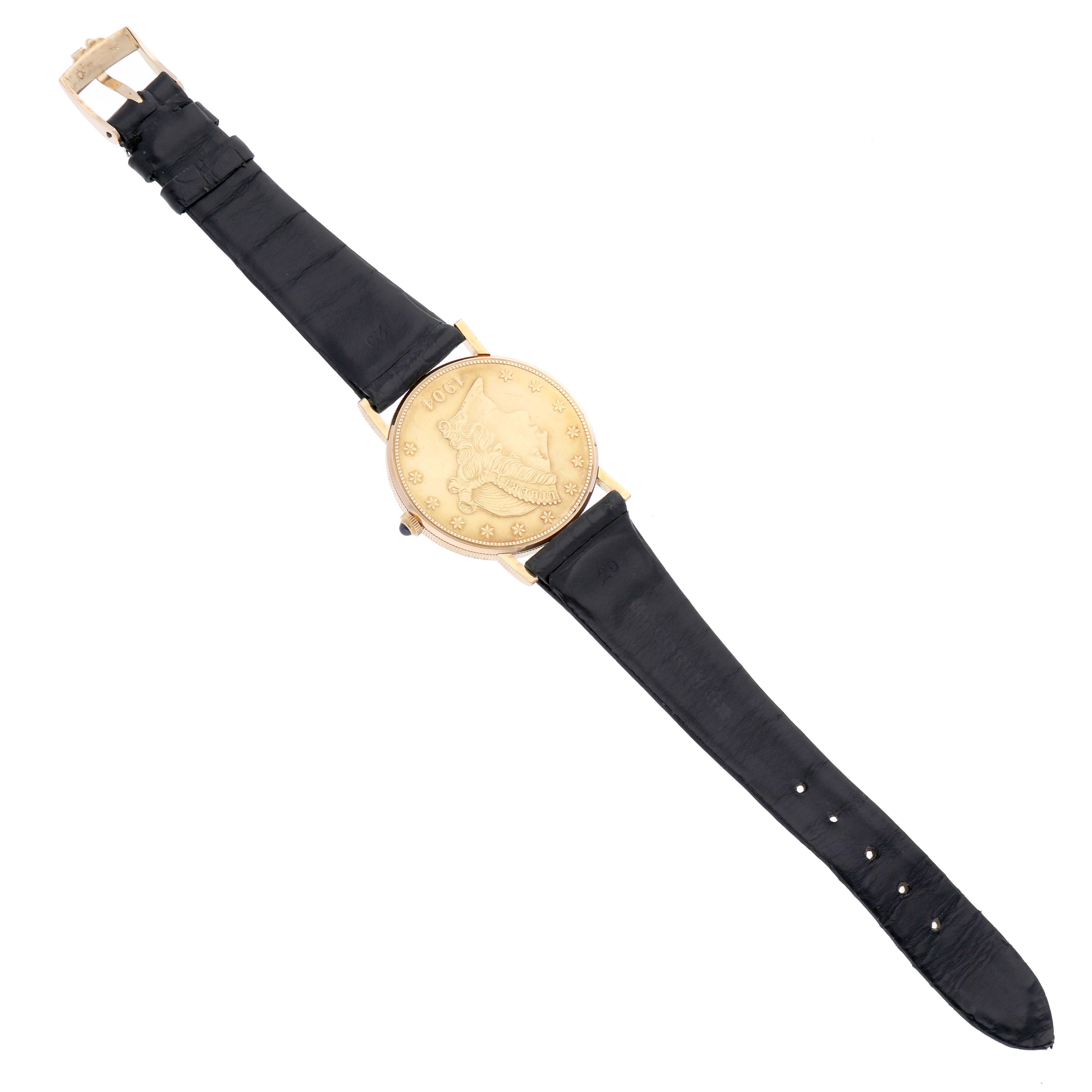 The image shows an overhead view of a Corum Coin Watch Men's Yellow Gold Yellow Dial Men's Yellow Gold Yellow Dial, featuring its black leather strap and gold coin-style watch face.