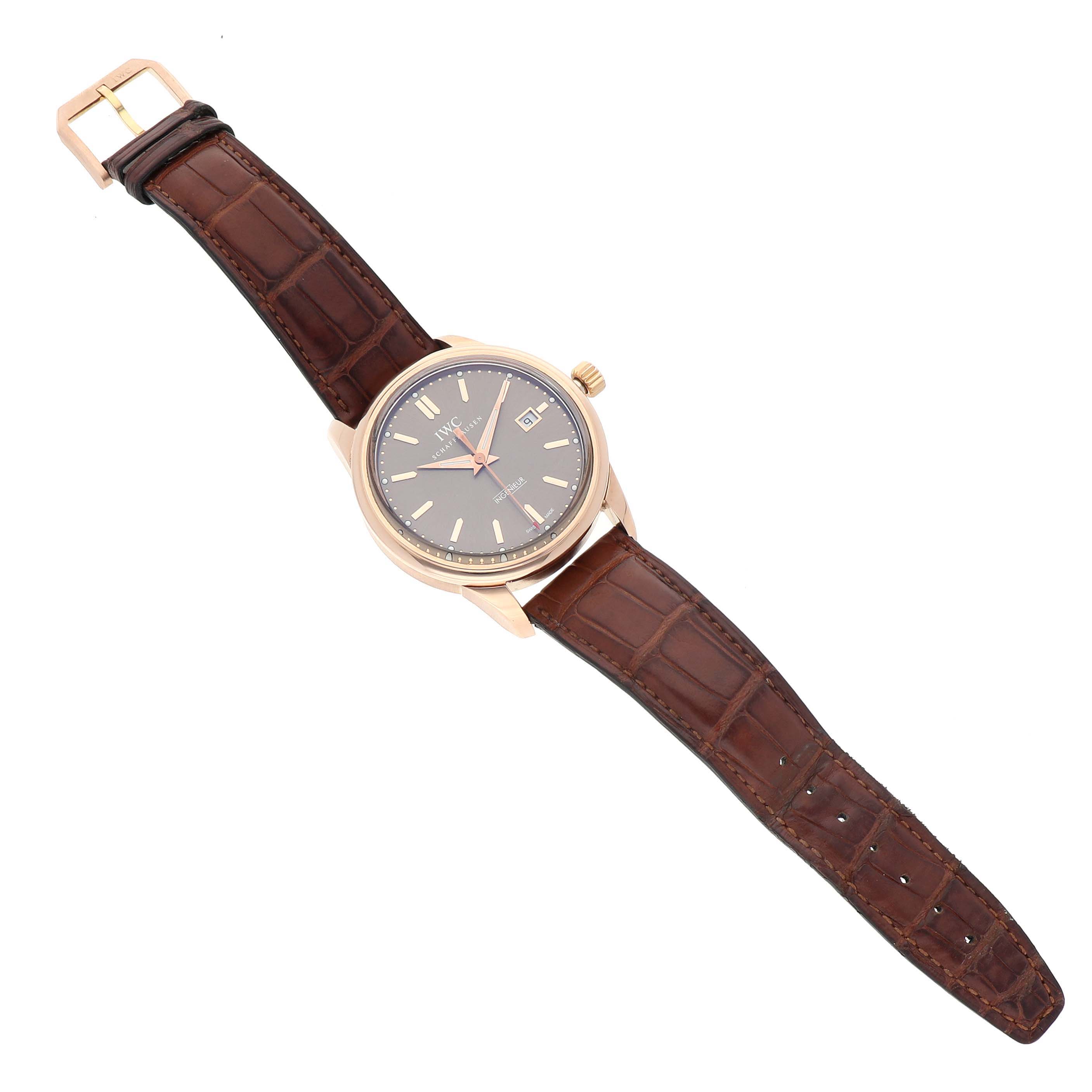 The IWC Ingenieur IW323312 Men's Rose Gold Brown Dial watch is shown face-up, displaying the dial, case, strap, and buckle.