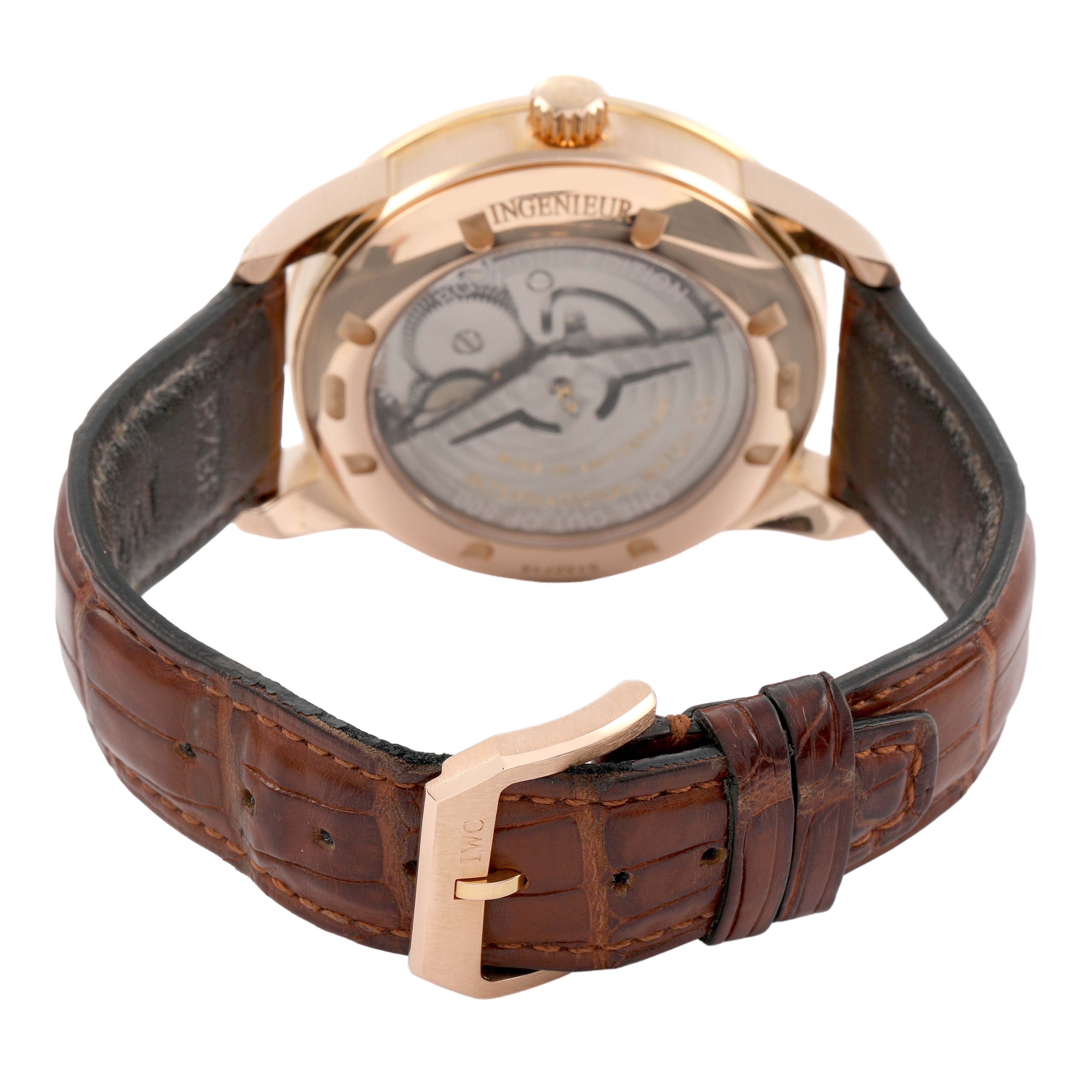 The image shows the back view of the IWC Ingenieur IW323312 Men's Rose Gold Brown Dial watch, highlighting its transparent case back and leather strap with buckle.