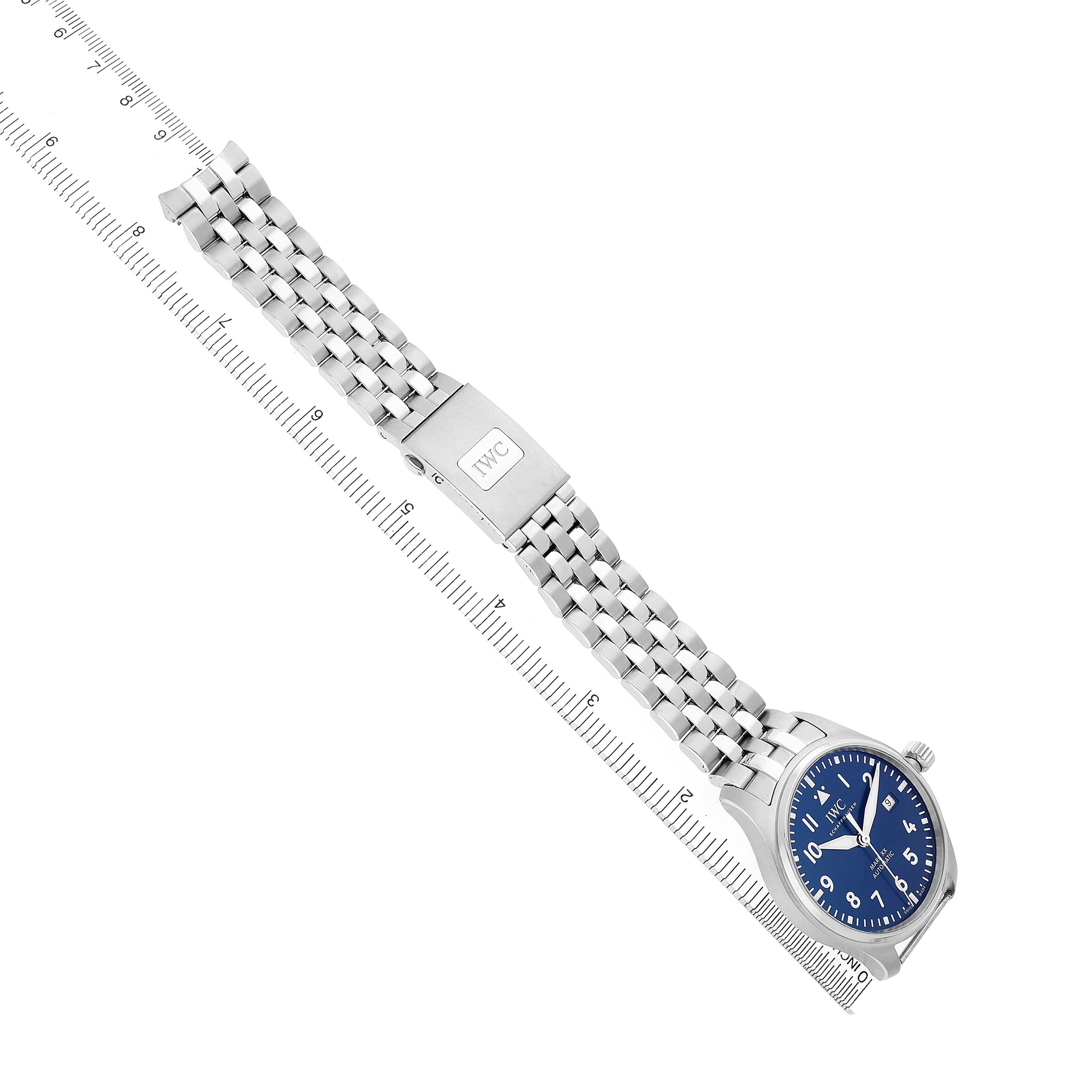 The IWC Pilot IW328204 Men's Stainless Steel Blue Dial watch is shown at an angle featuring the face, stainless steel bracelet, and clasp, with a measuring ruler beside it.