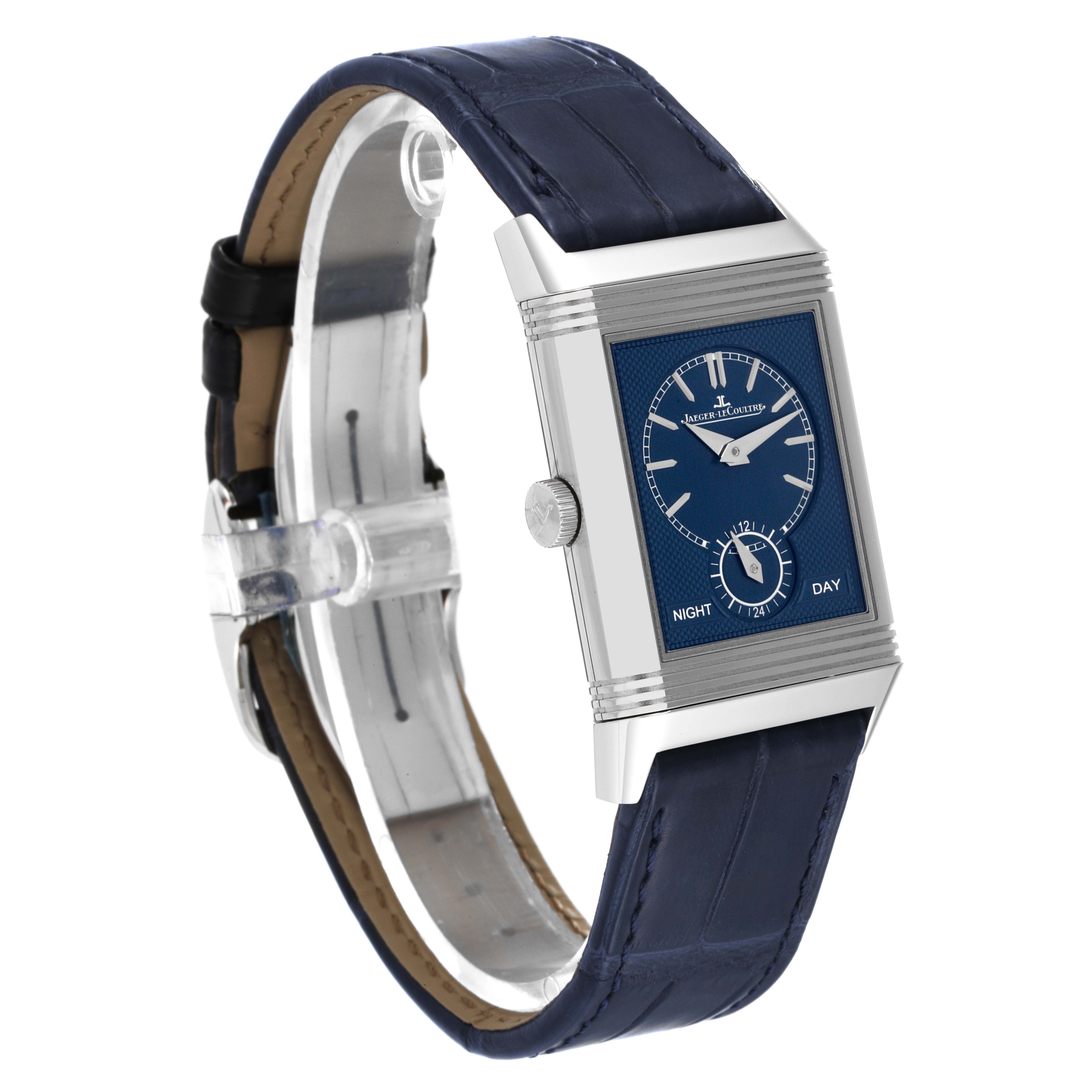 The Jaeger-LeCoultre Reverso watch is shown at an angle displaying its face, crown, and blue leather strap.