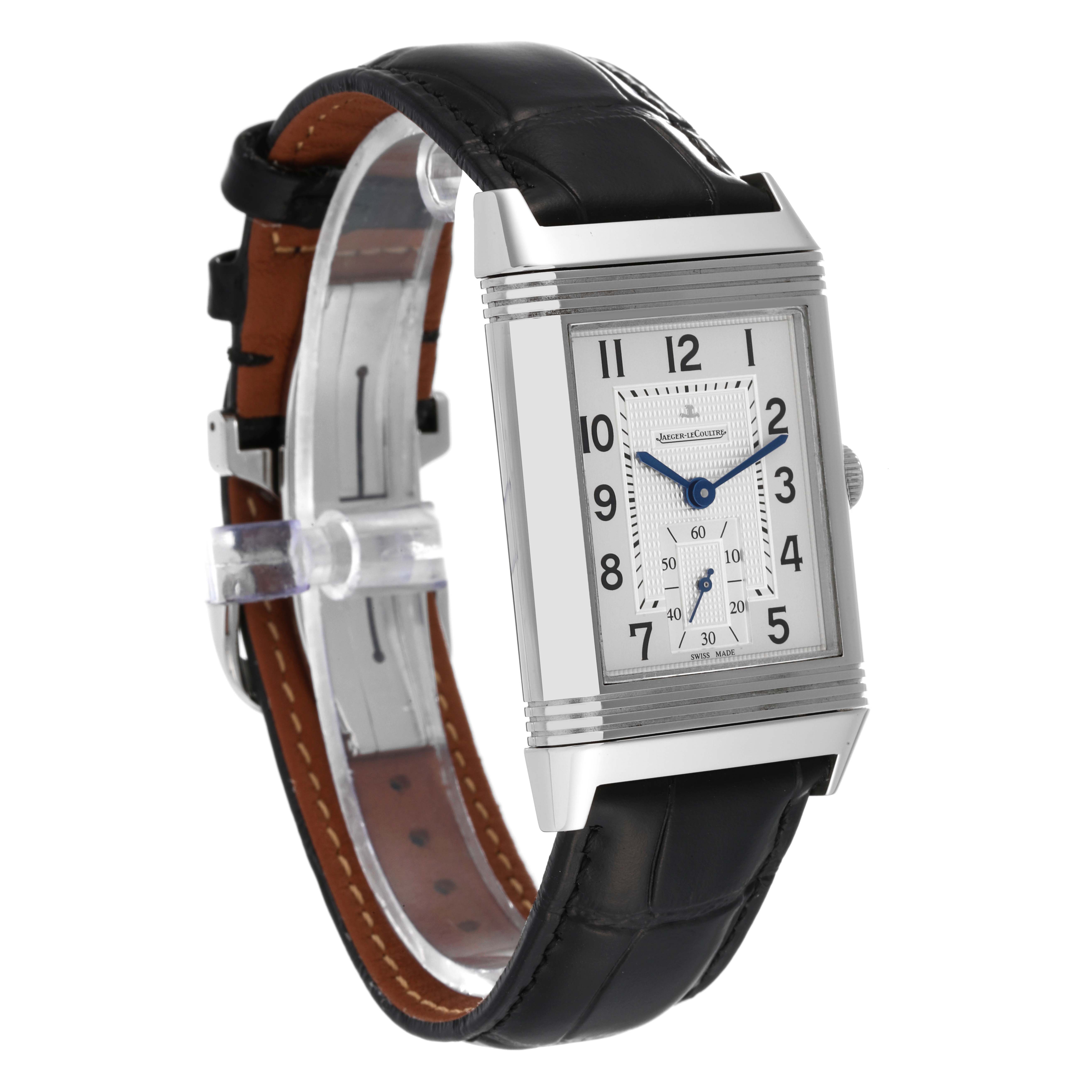 The image shows a Jaeger-LeCoultre Reverso watch at a slight angle, highlighting its rectangular face, leather strap, and blue hands.