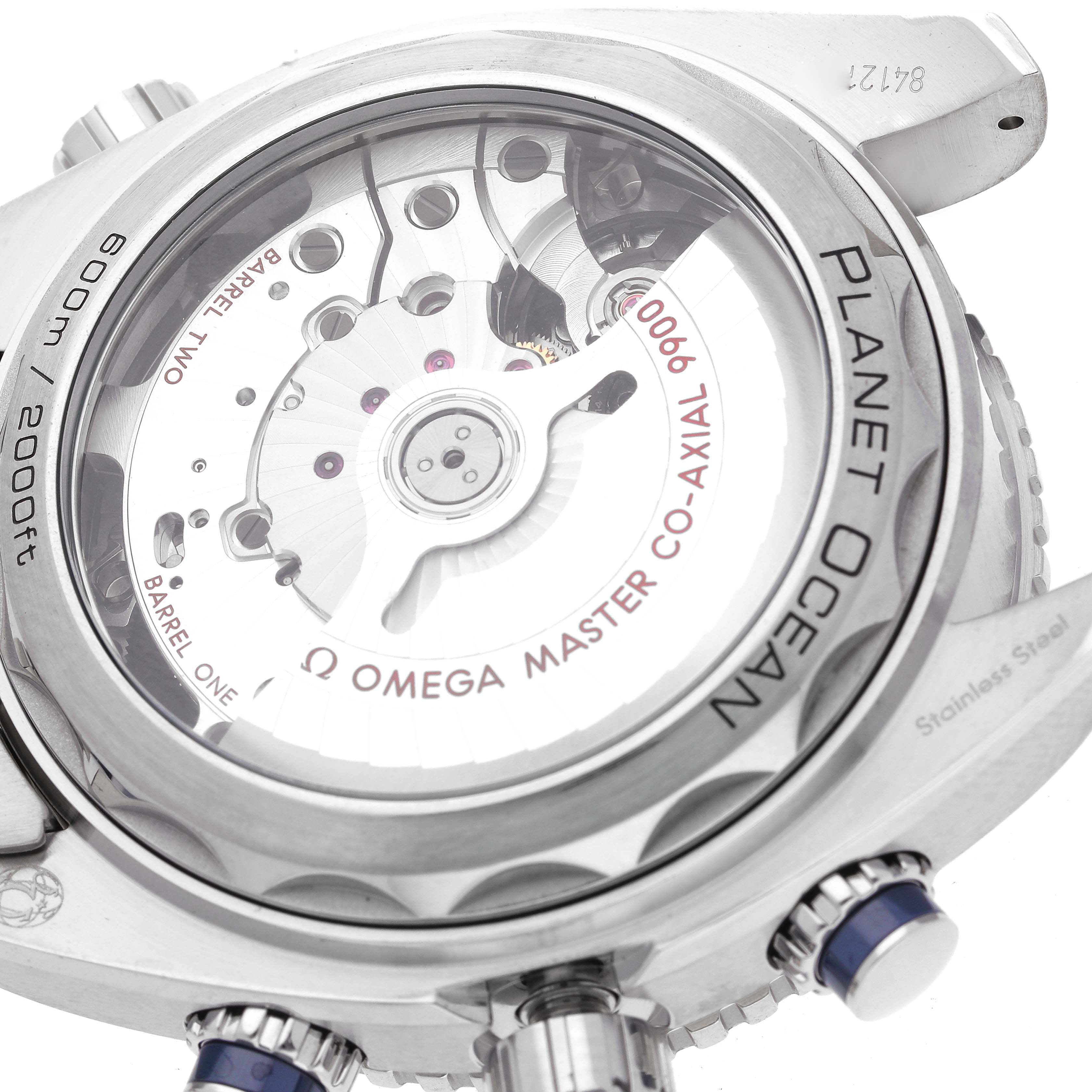 The image shows the back view of an Omega Planet Ocean 215.30.46.51.03.001 Men's Stainless Steel Blue Dial 215.30.46.51.03.001 Men's Stainless Steel Blue Dial watch, highlighting the internal mechanism and "Omega Master Co-Axial 9000" text.