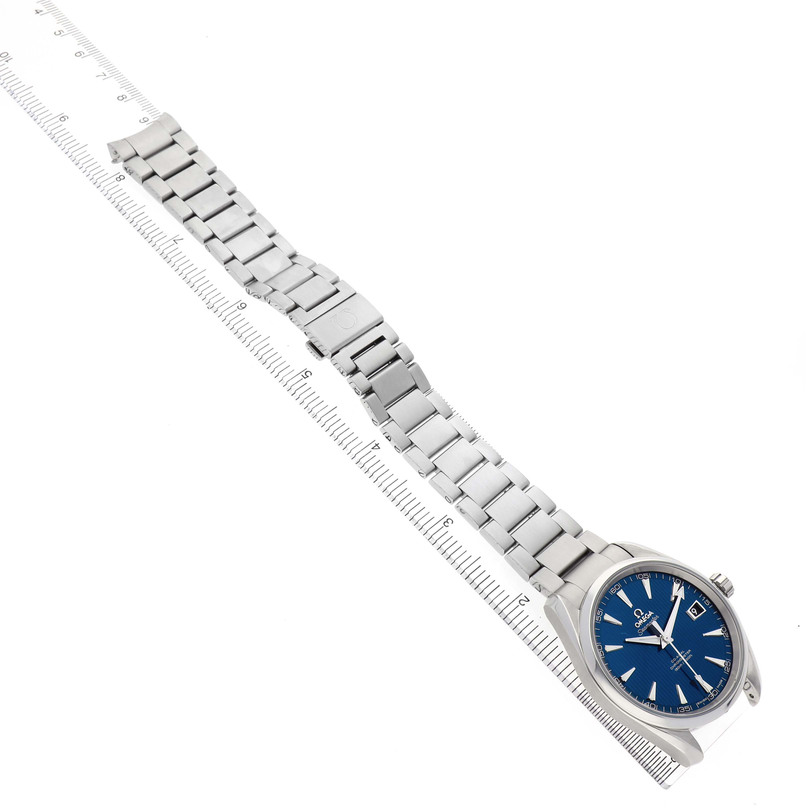 The Omega Seamaster 231.10.42.21.03.001 Men's Stainless Steel Blue Dial watch is shown at an angle displaying its face, bracelet, and clasp alongside a measuring ruler.
