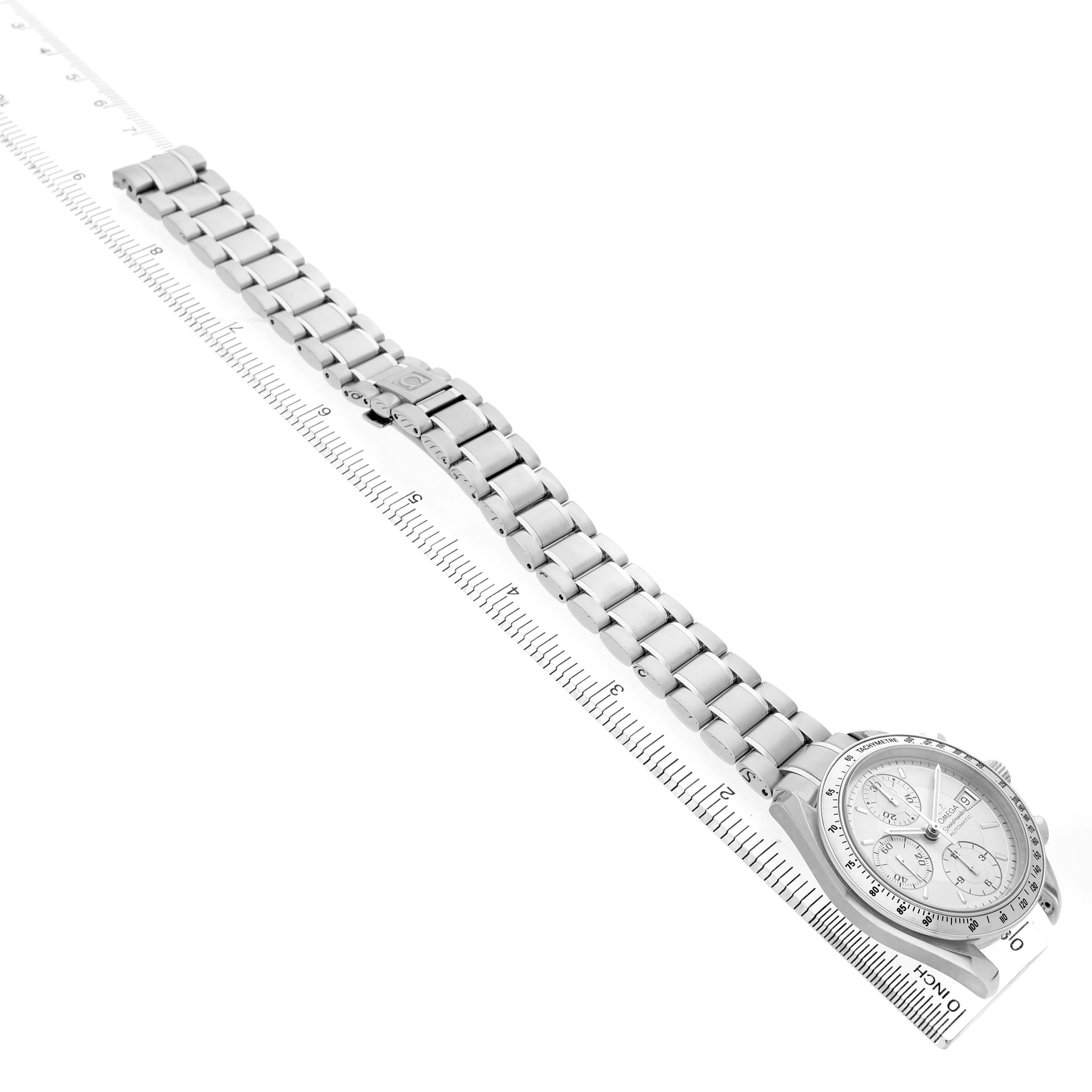 The Omega Speedmaster 3513.30.00 Men's Stainless Steel Silver Dial watch is shown from an angled overhead view, displaying the bracelet and face alongside a ruler for scale.