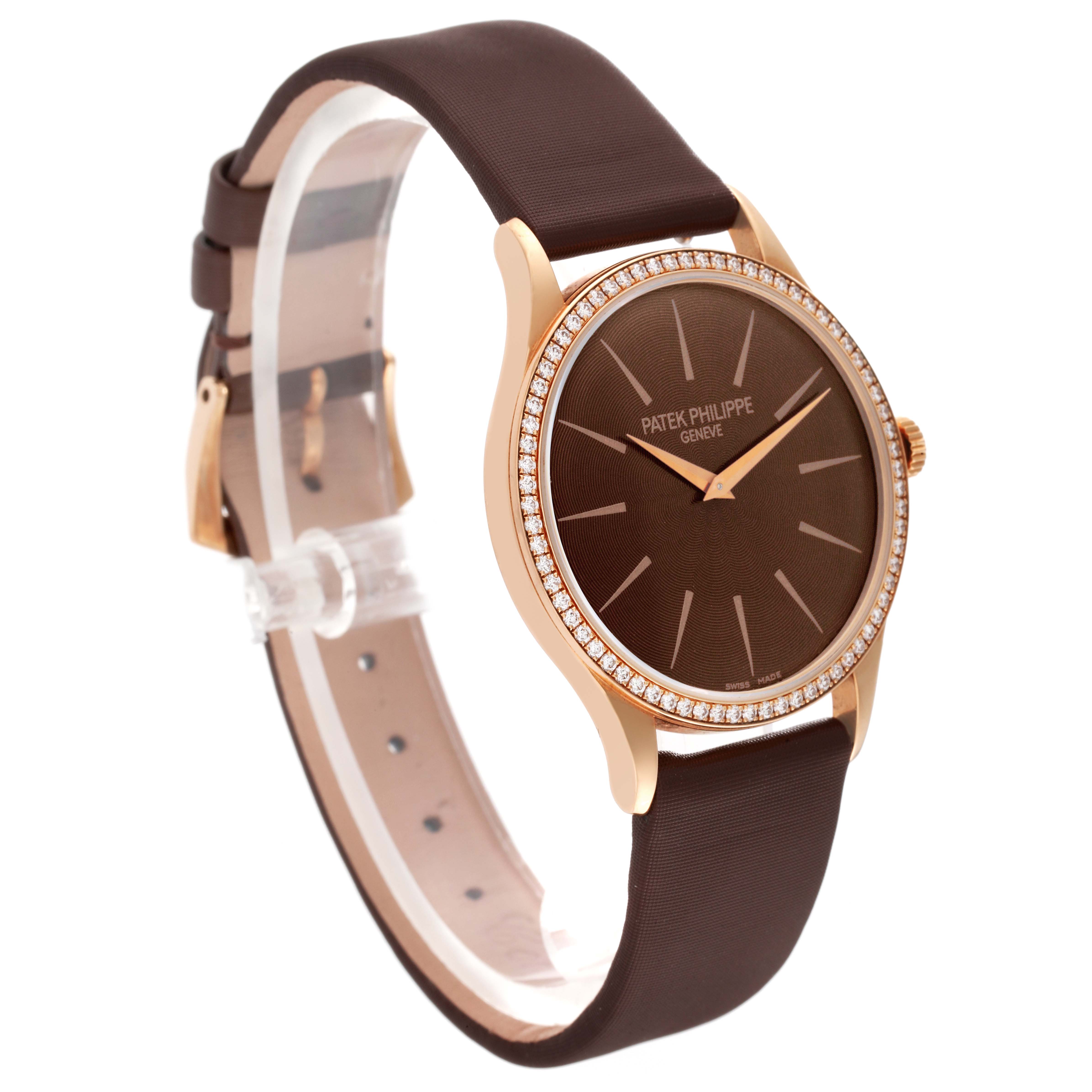 This Patek Philippe Calatrava 4897R-001 Women's Rose Gold Brown Dial 4897R-001 Women's Rose Gold Brown Dial model watch is shown from a three-quarter angle, displaying its brown dial, diamond-set bezel, and brown leather strap.