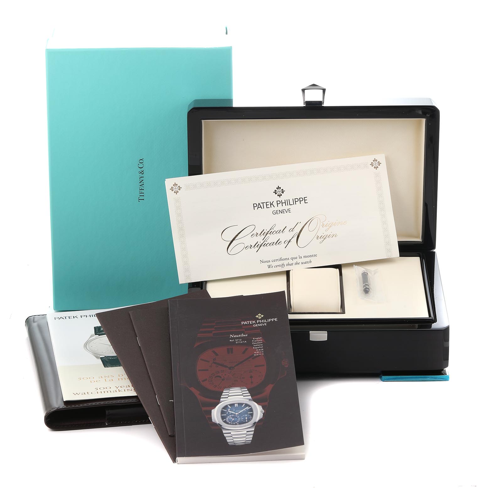 The image shows a Patek Philippe Nautilus 5712/1A-001 Men
s Stainless Steel Blue Dial 5712/1A-001 Men
s Stainless Steel Blue Dial watch box, its certificate, booklets, and packaging at a frontal angle.