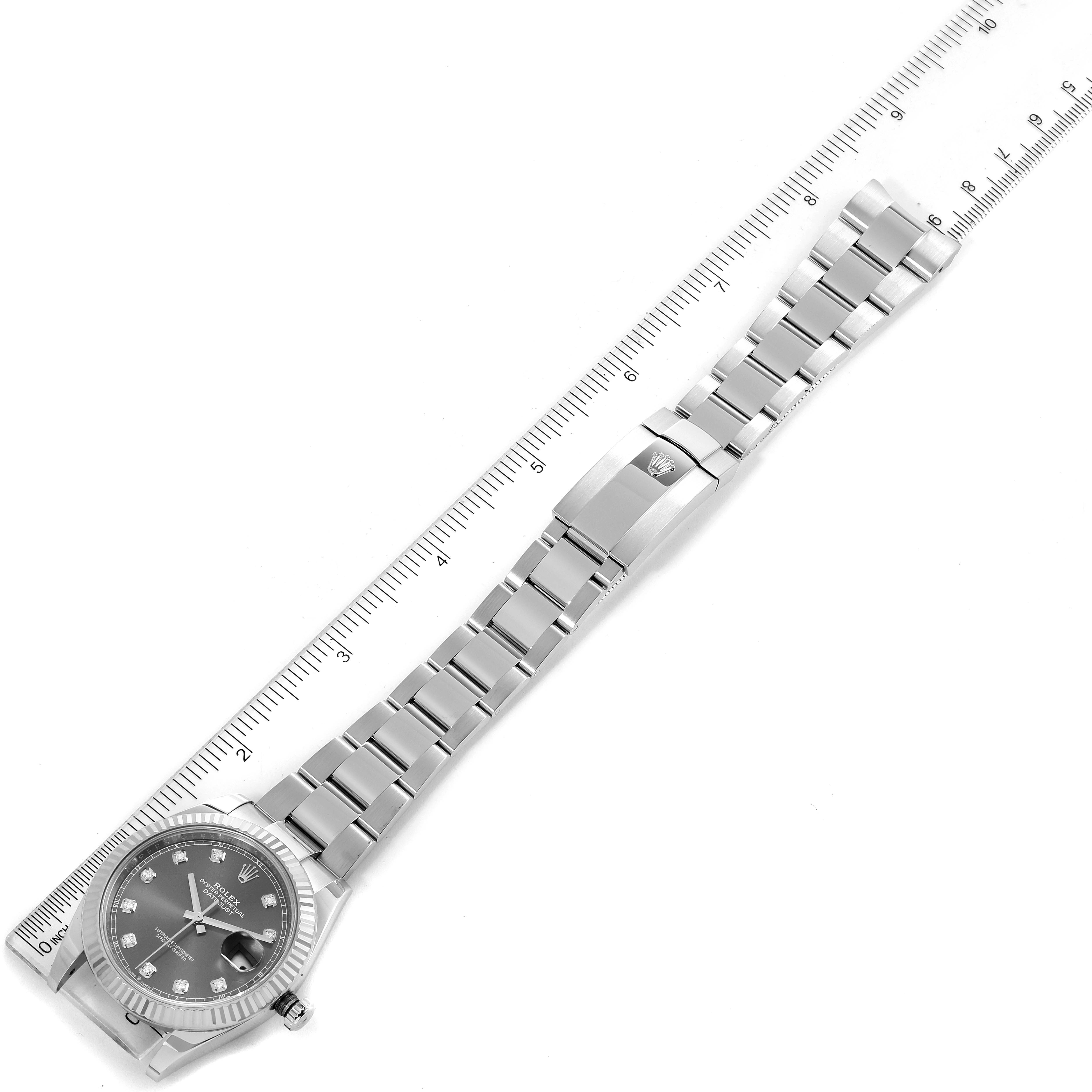 This image shows the Rolex Datejust 41 126334 Men
s Stainless Steel Grey Dial 126334 Men
s Stainless Steel Grey Dial watch laid flat with its bracelet extended, alongside a ruler.