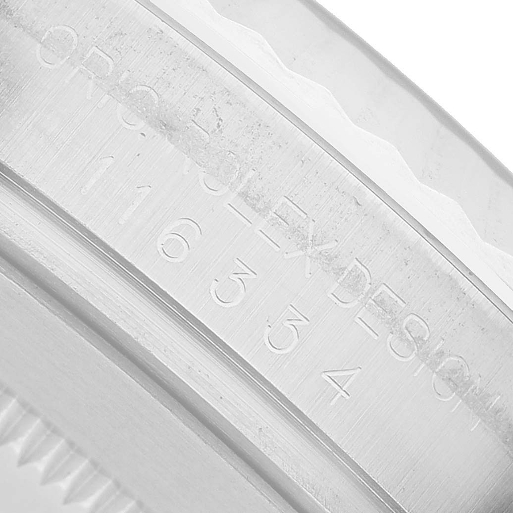 The image shows a close-up of the engraved bezel of a Rolex Datejust 116334 Men's Stainless Steel Blue Dial, focusing on the model details.