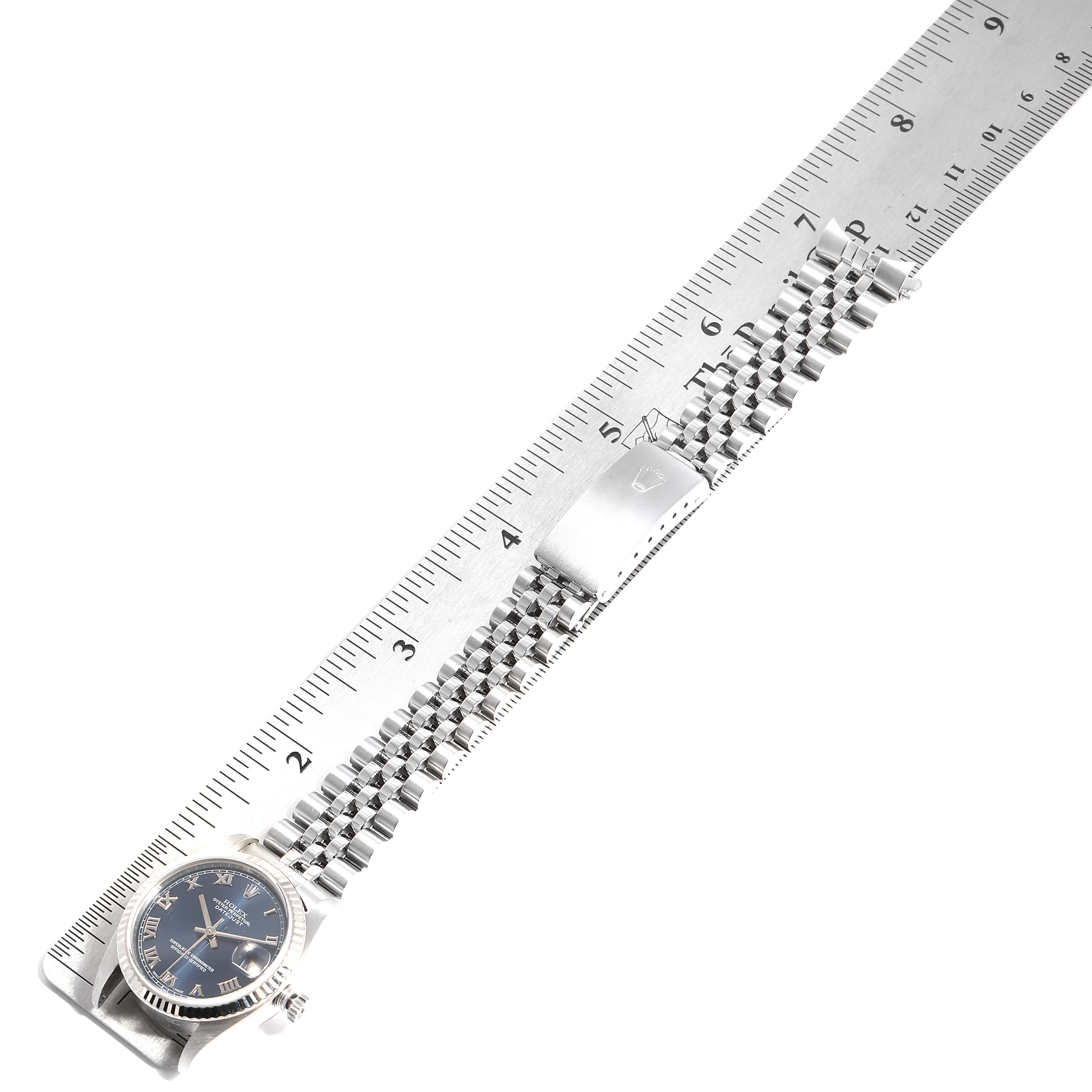 The image shows a top-down view of a Rolex Mid-Size 28322 Women
s Stainless Steel Blue Dial 28322 Women
s Stainless Steel Blue Dial watch, featuring the bracelet extended alongside a ruler.